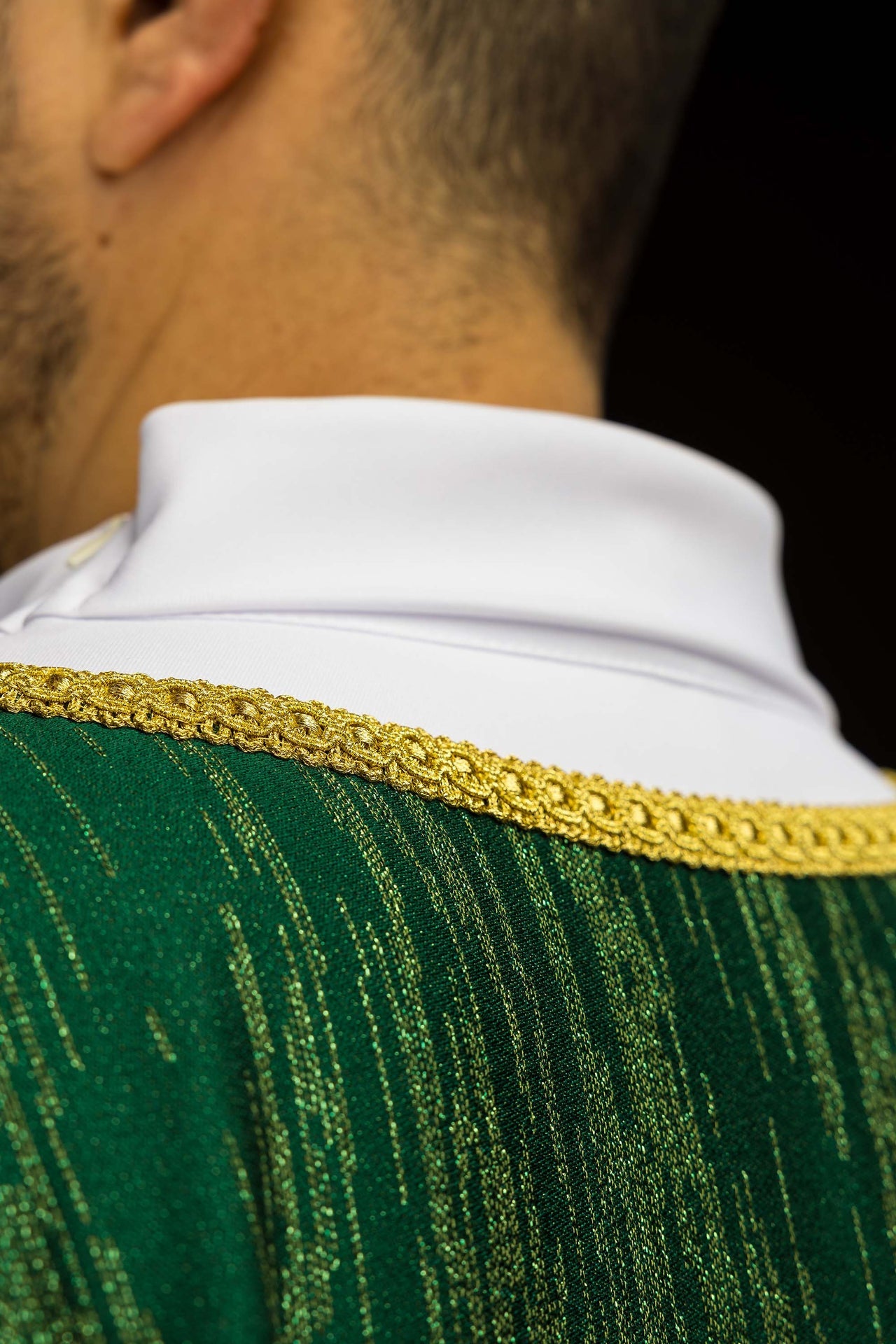 Green chasuble with embroidered cross motif on decorative fabric