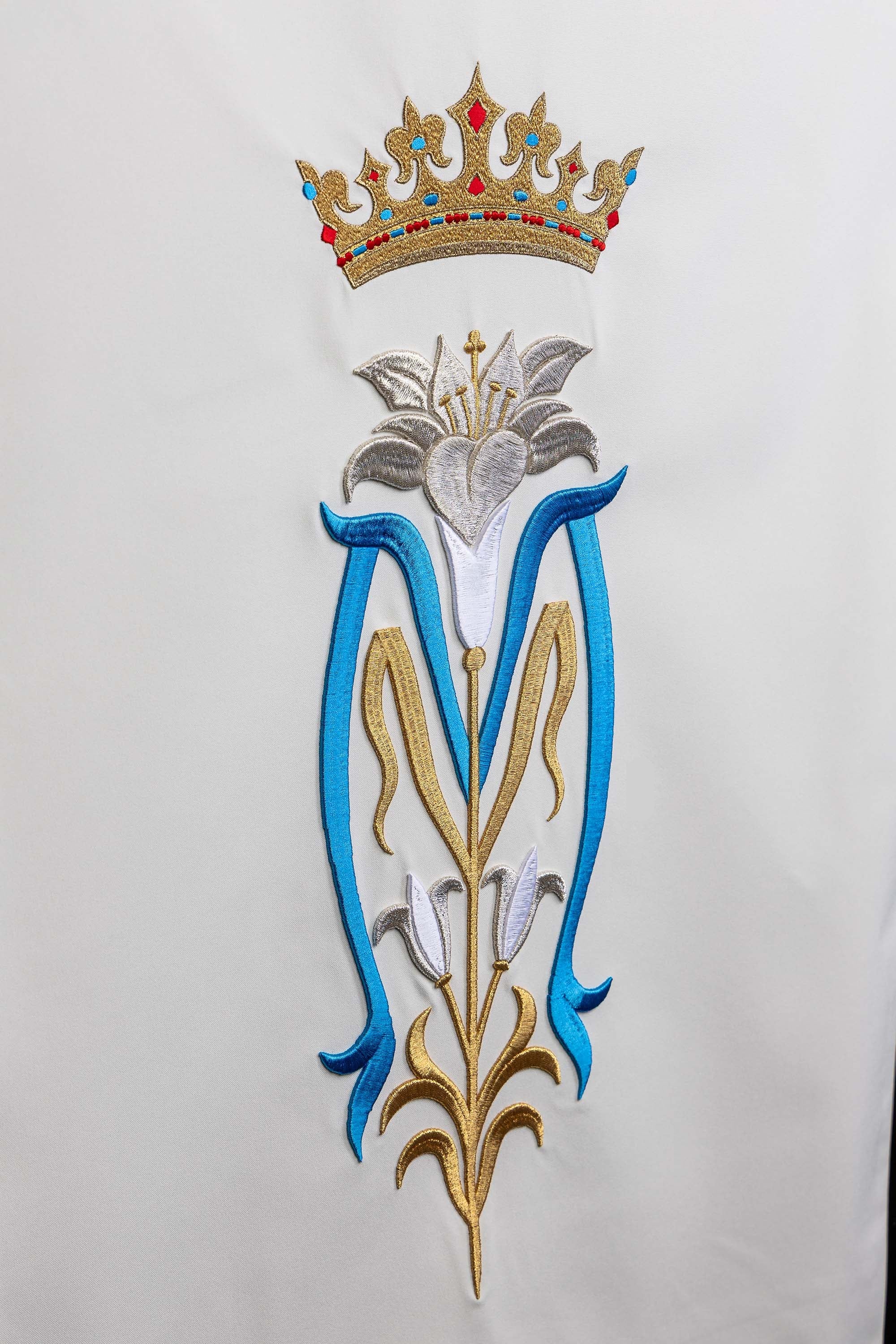 White lectern cover embroidered with a white Marian motif