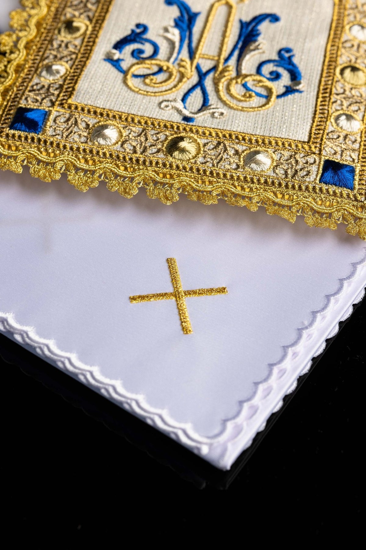 Close-up of the chalice linen set showing gold cross embroidery, scalloped edges, and ornate trim