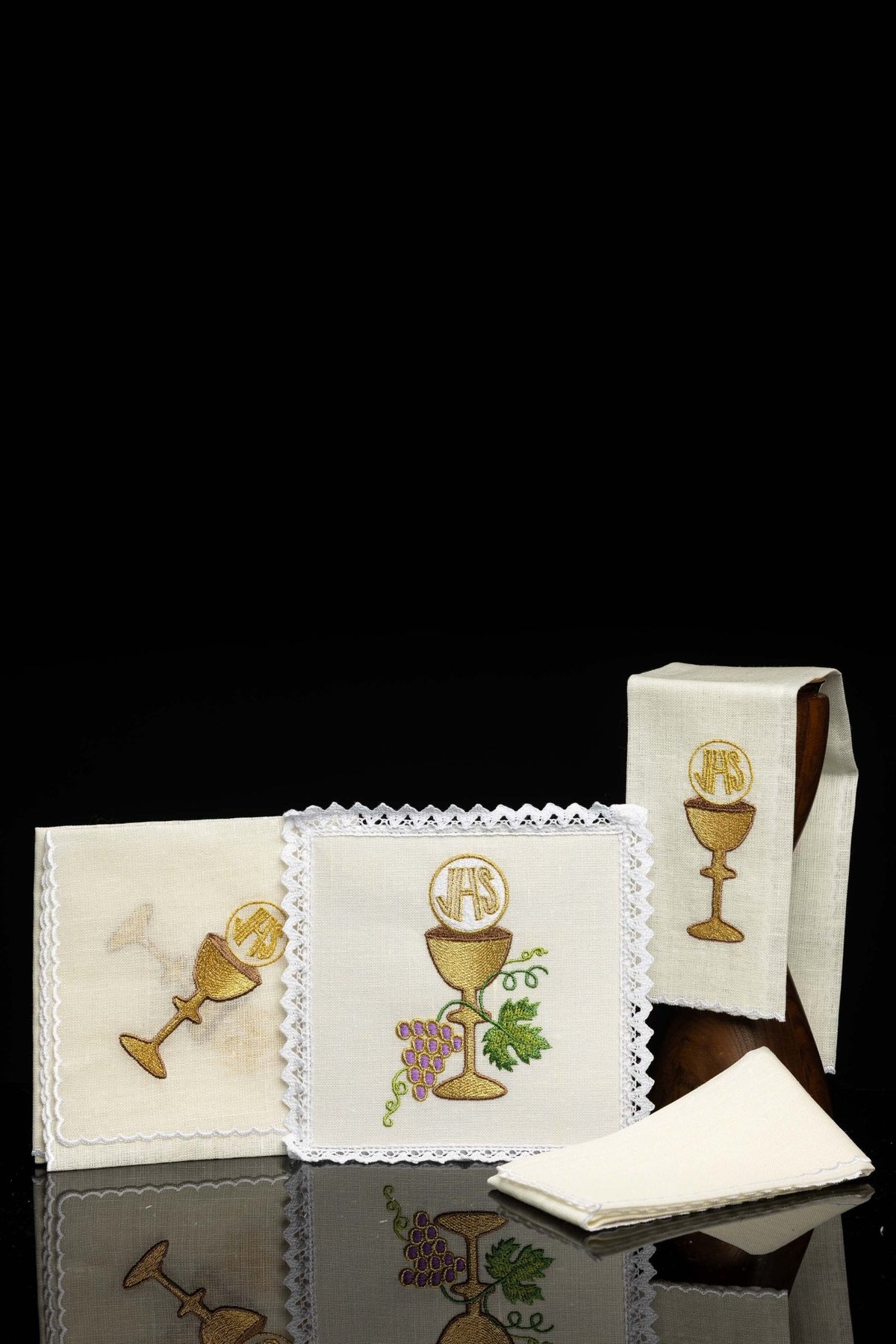 Front view of a Chalice linen with embroidered chalice motif, showing cream linens with chalices and lace trim