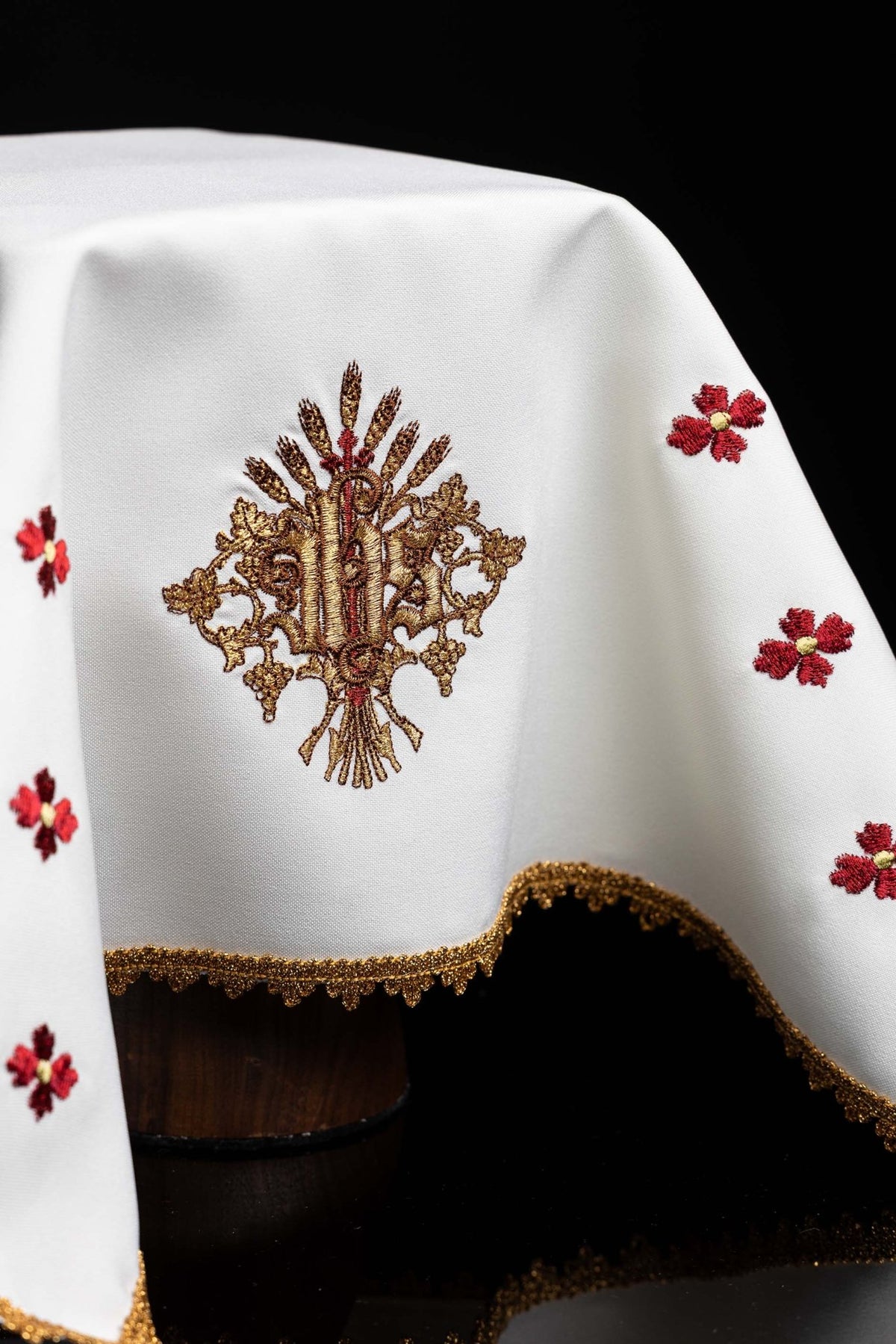 Front detail of chalice veil with embroidered IHS motif, red flowers, and gold scalloped trim