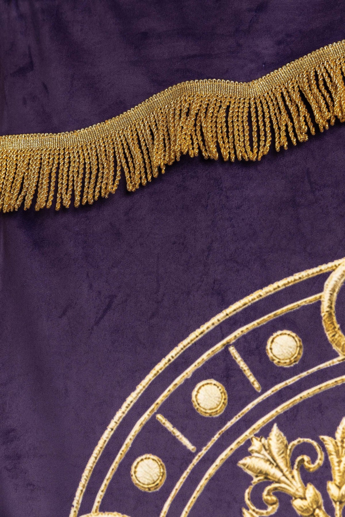 Close-up of the purple banner showing gold fringe and circular back motif