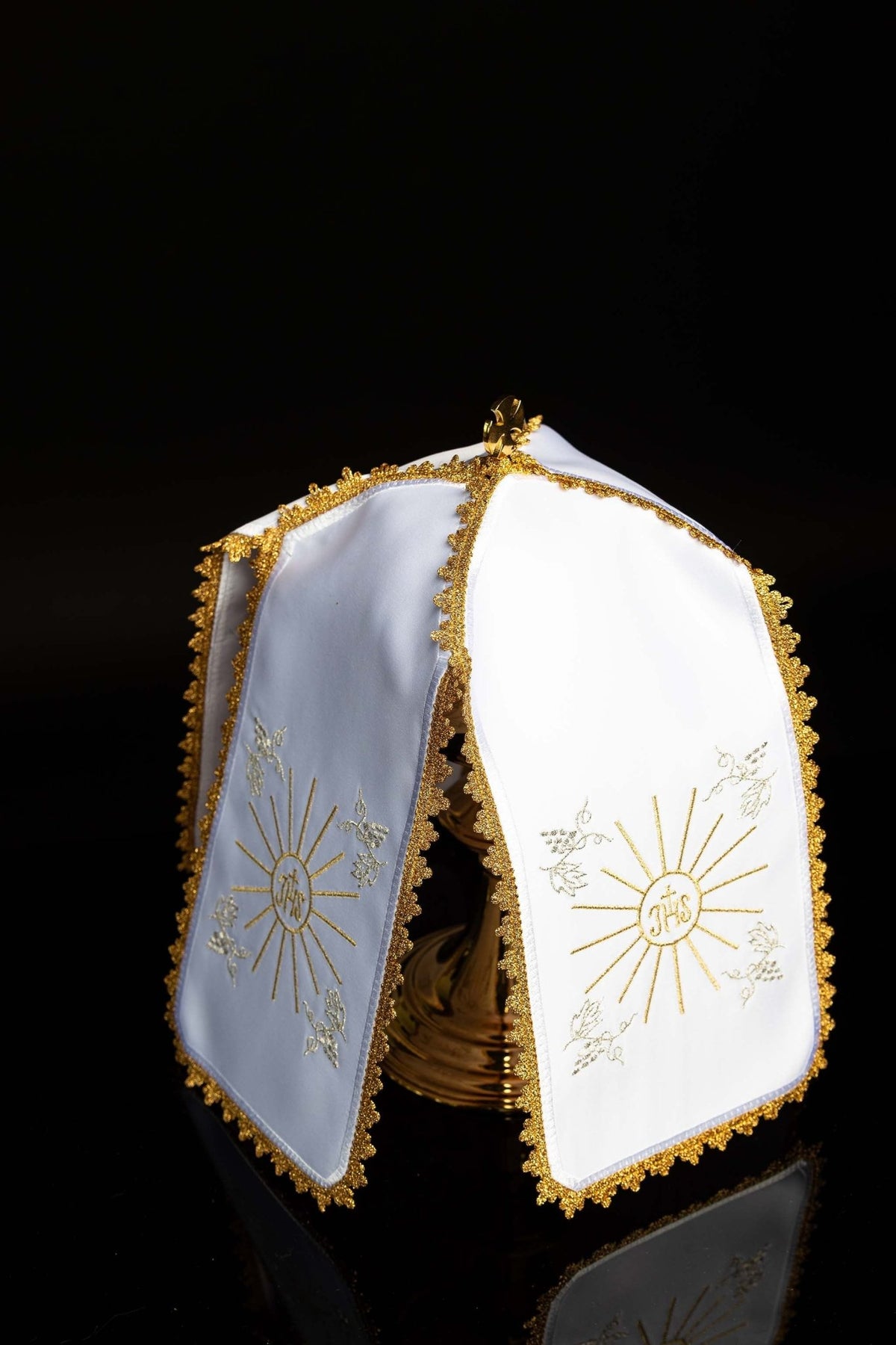 Angled view of the ciborium veil showing matching IHS embroidery on white and pale blue panels