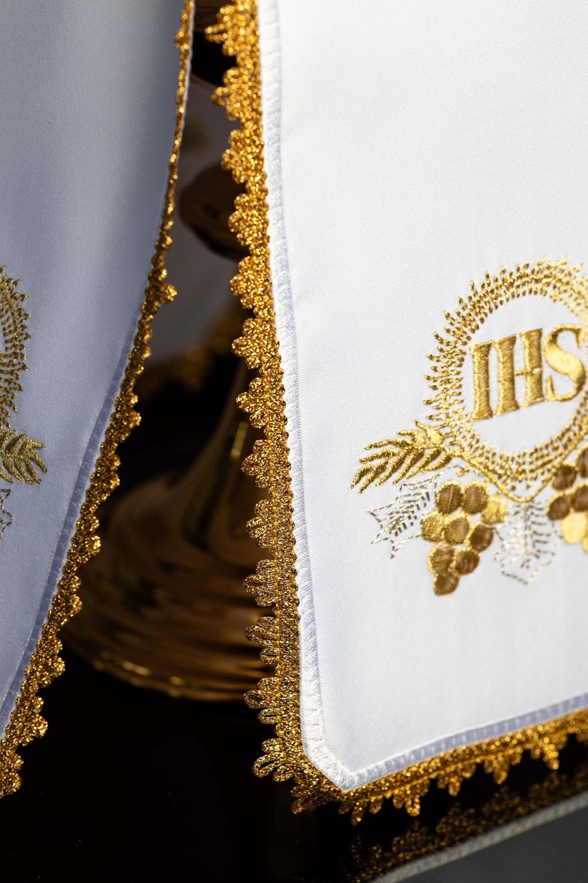 Close-up side view of the ciborium veil showing ornate gold edging and partial IHS motif
