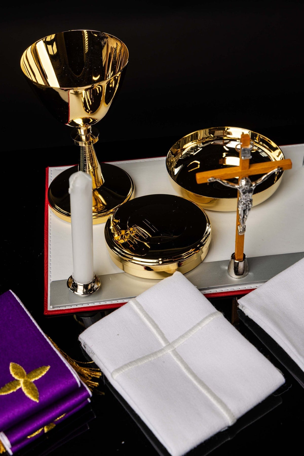 Open view of a Mission Suitcase Equipped with Liturgical Equipment with gold chalice, paten, cross and white altar linens