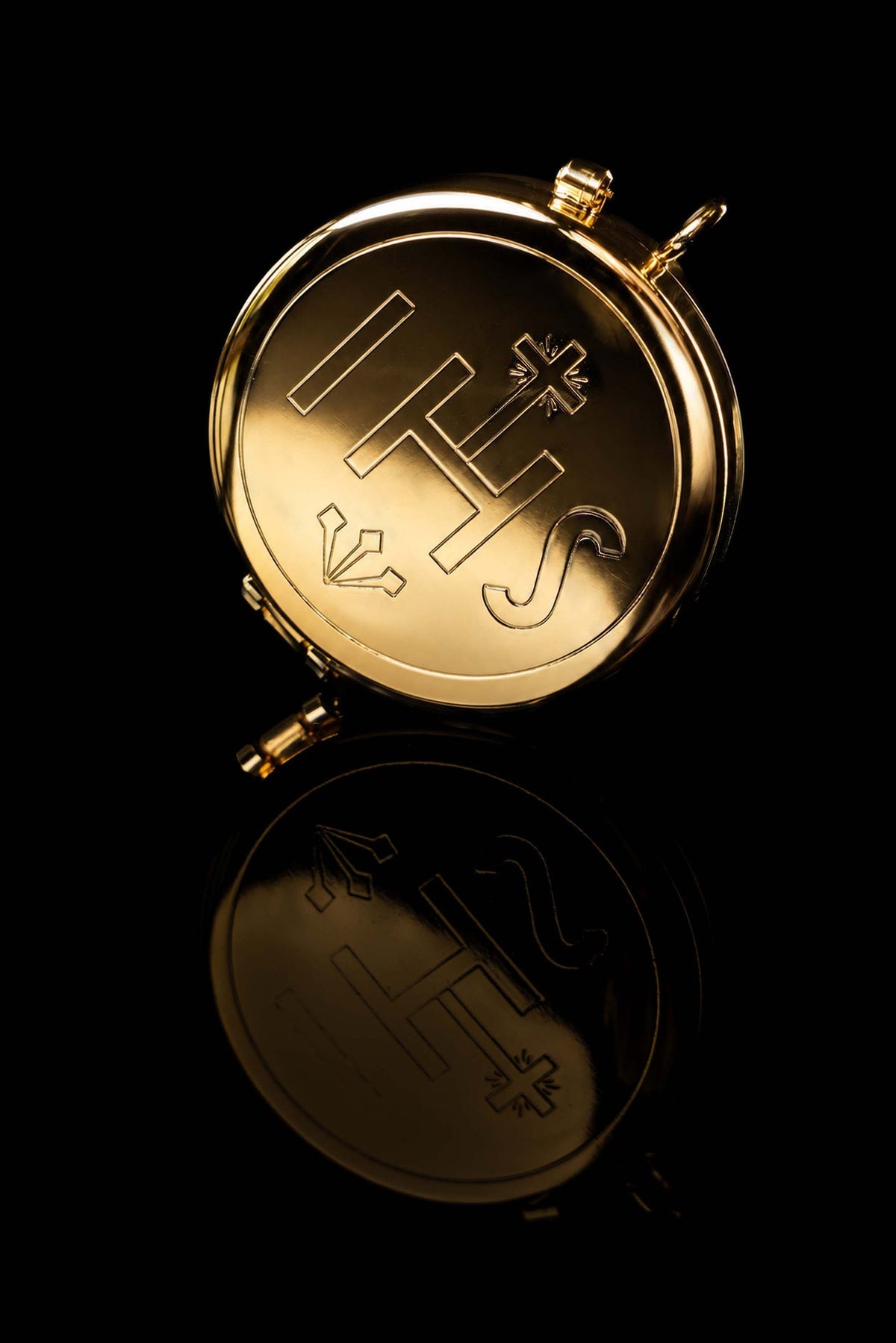 Top view of a gold-plated ciborium with IHS engraving, showing the cross and surrounding symbols