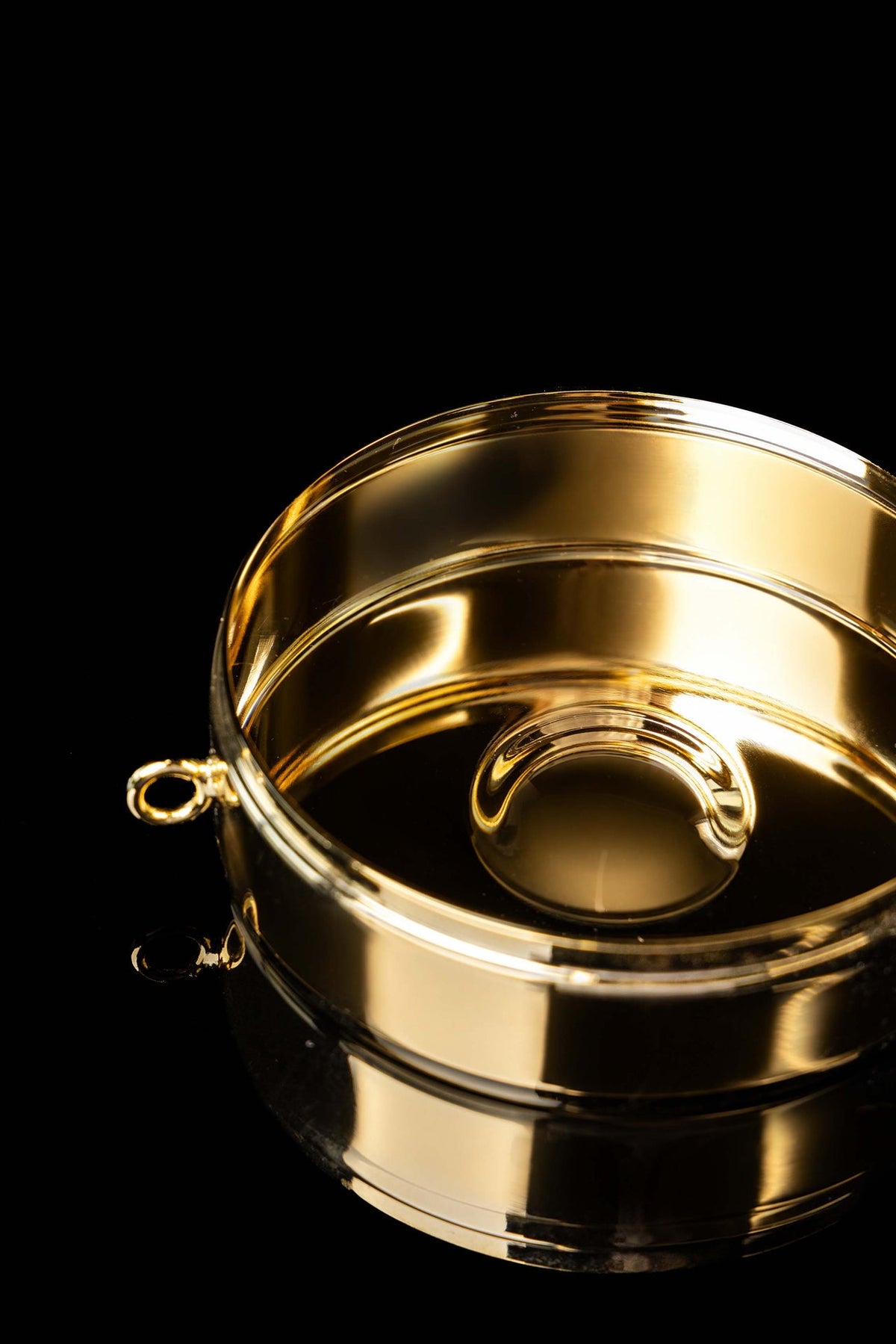 Open view of the gold-plated ciborium showing its polished interior and raised base