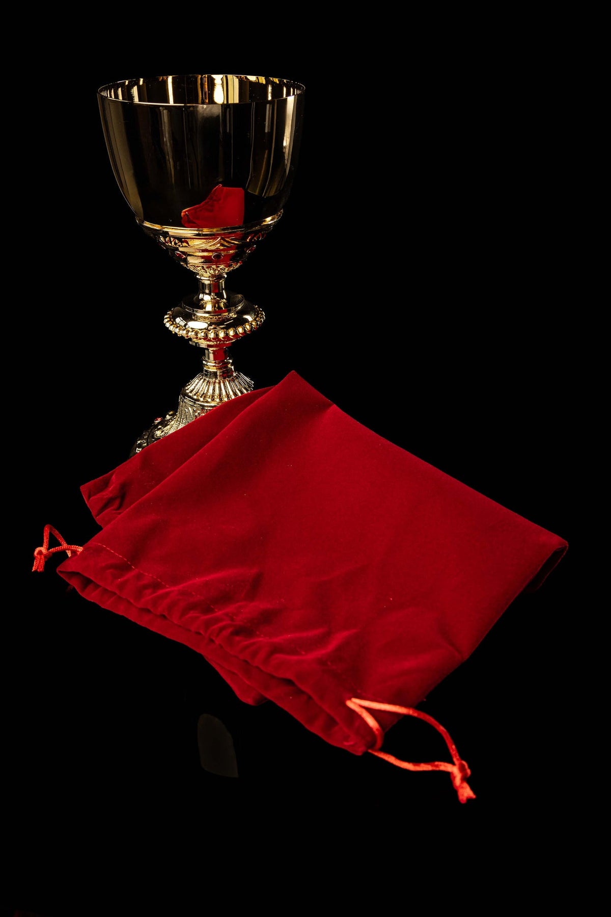 Angled view of the gold-plated chalice with a red fabric liner and ruby-colored accents