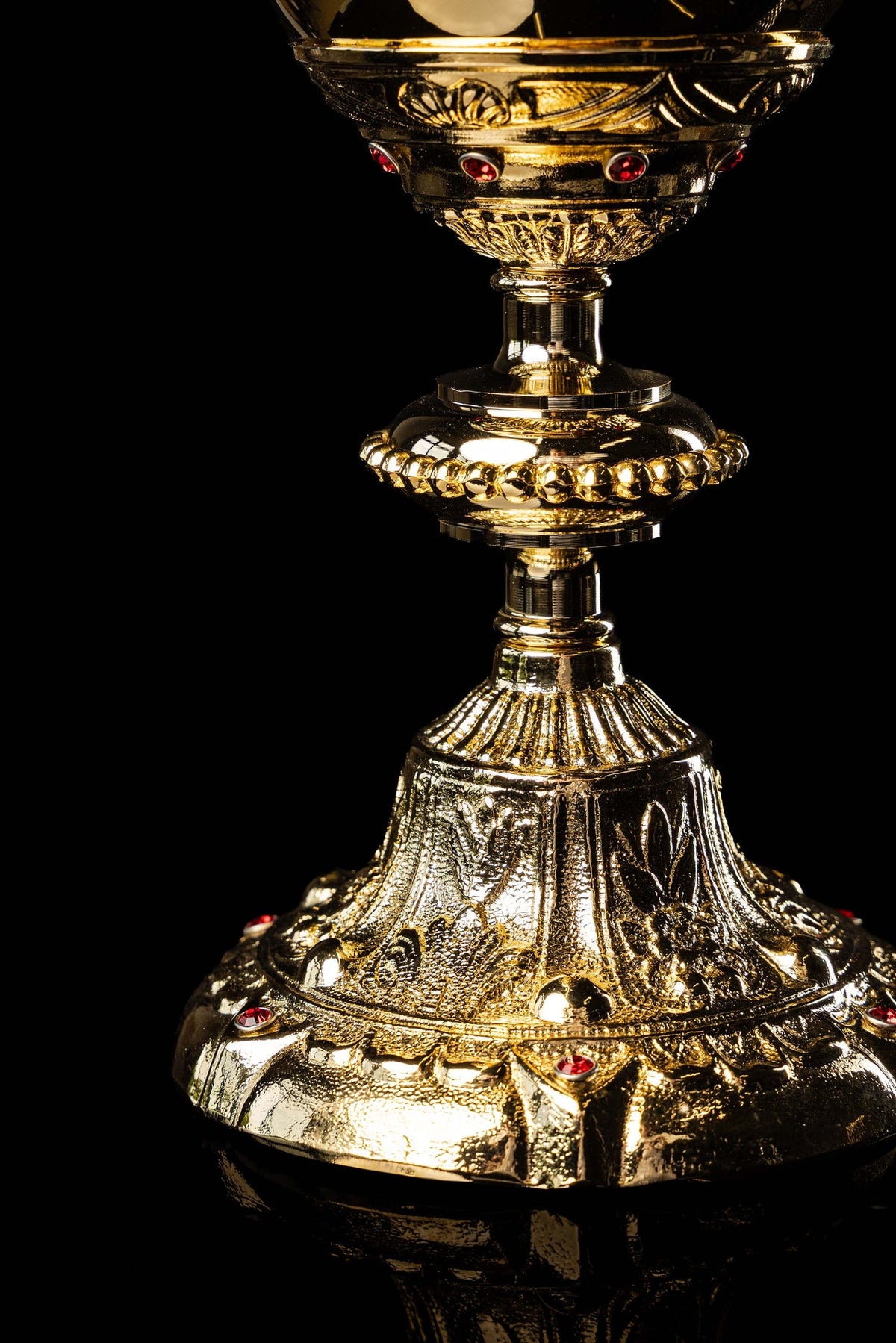 Close-up of the gold-plated chalice stem and ornate flared base with red stones
