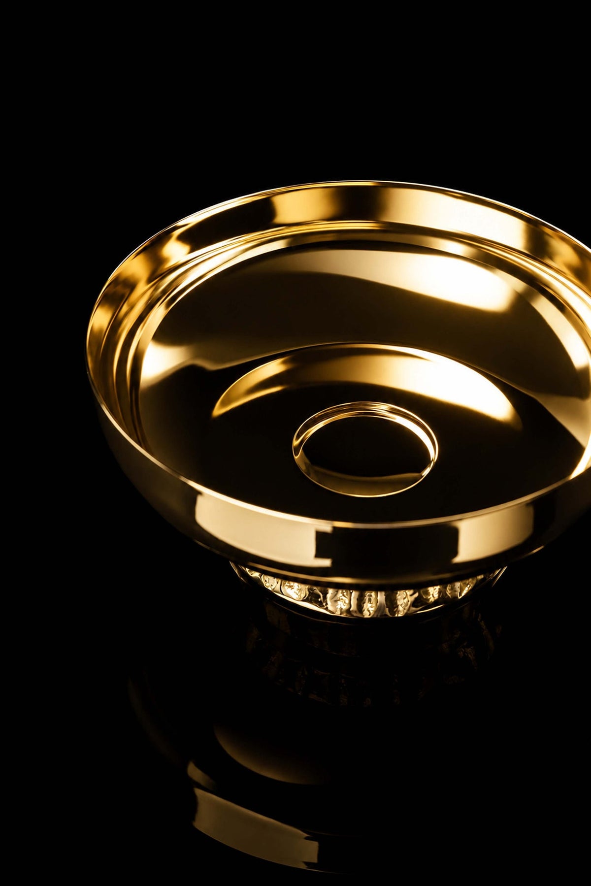 Close-up of the gold-plated paten showing its smooth interior and central fluted nodus
