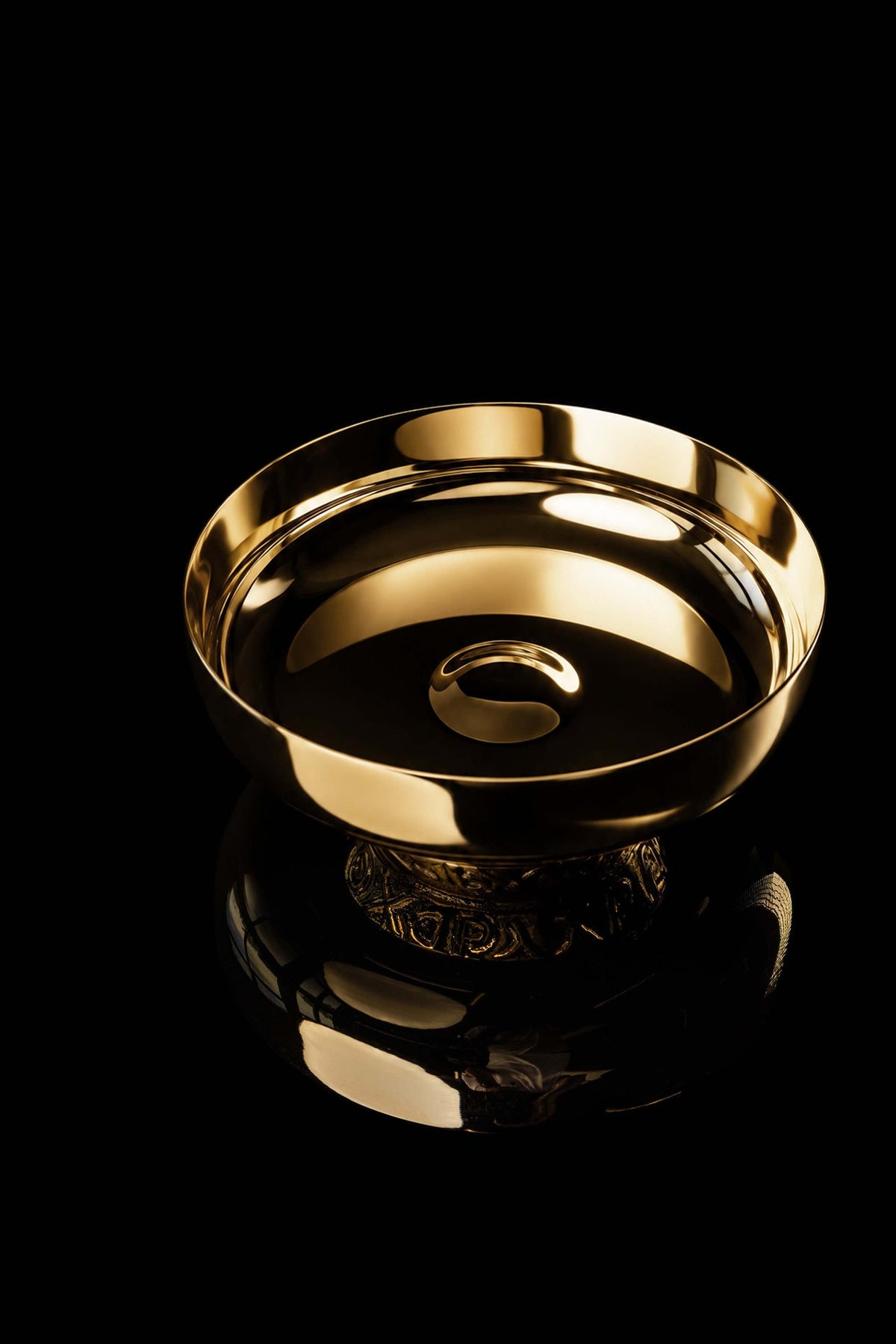 Top view of the gold-plated paten showing the smooth reflective bowl and central nodus