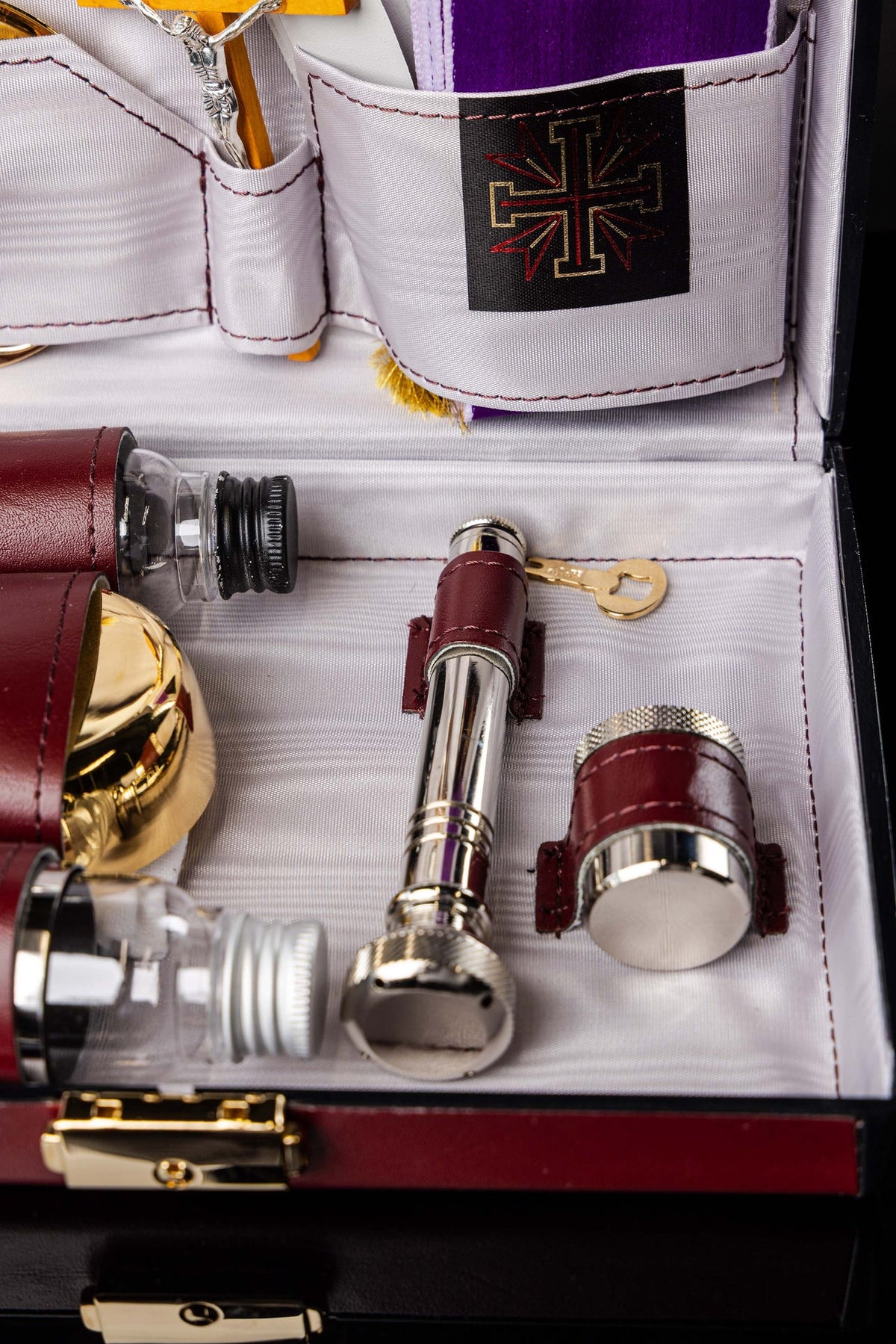 Close-up of equipment suitcase holding glass bottles, gold vessel and silver accessory