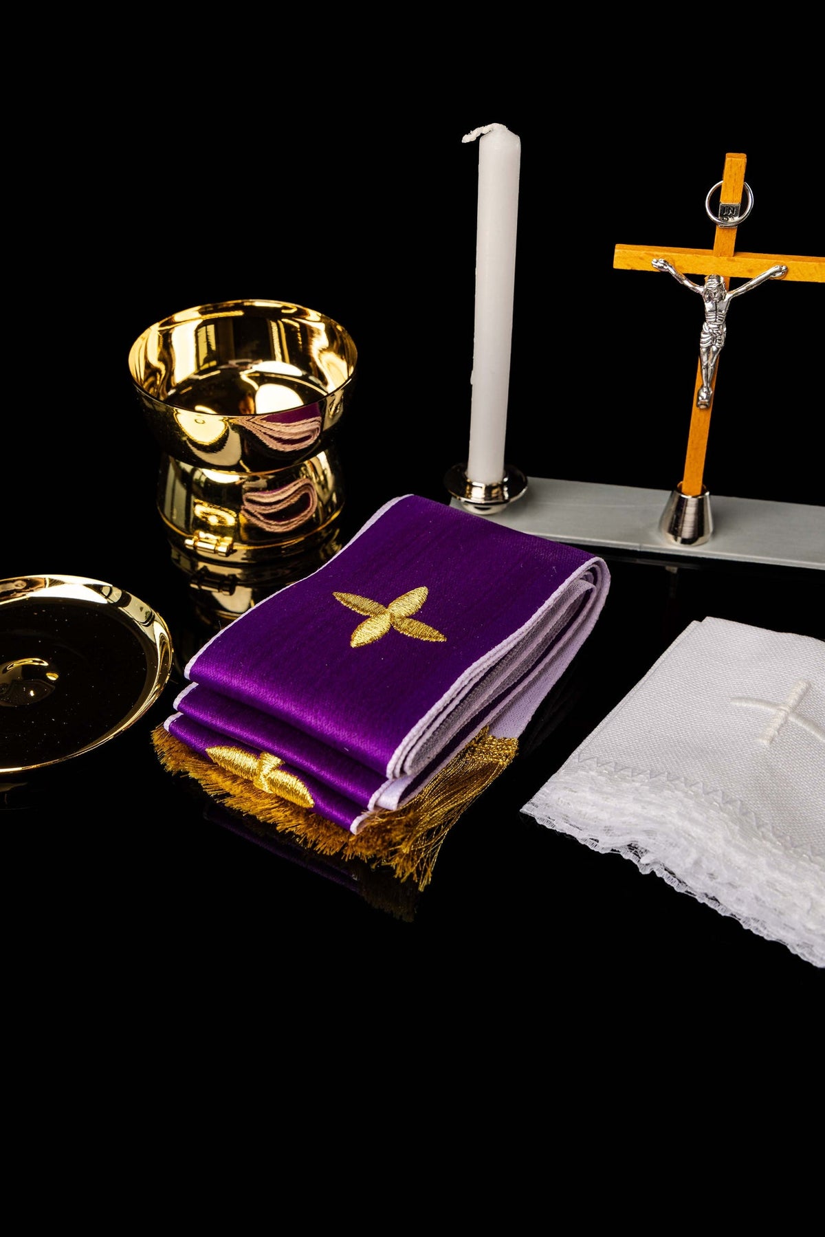 Gold vessel and candle displayed with the equipment suitcase contents