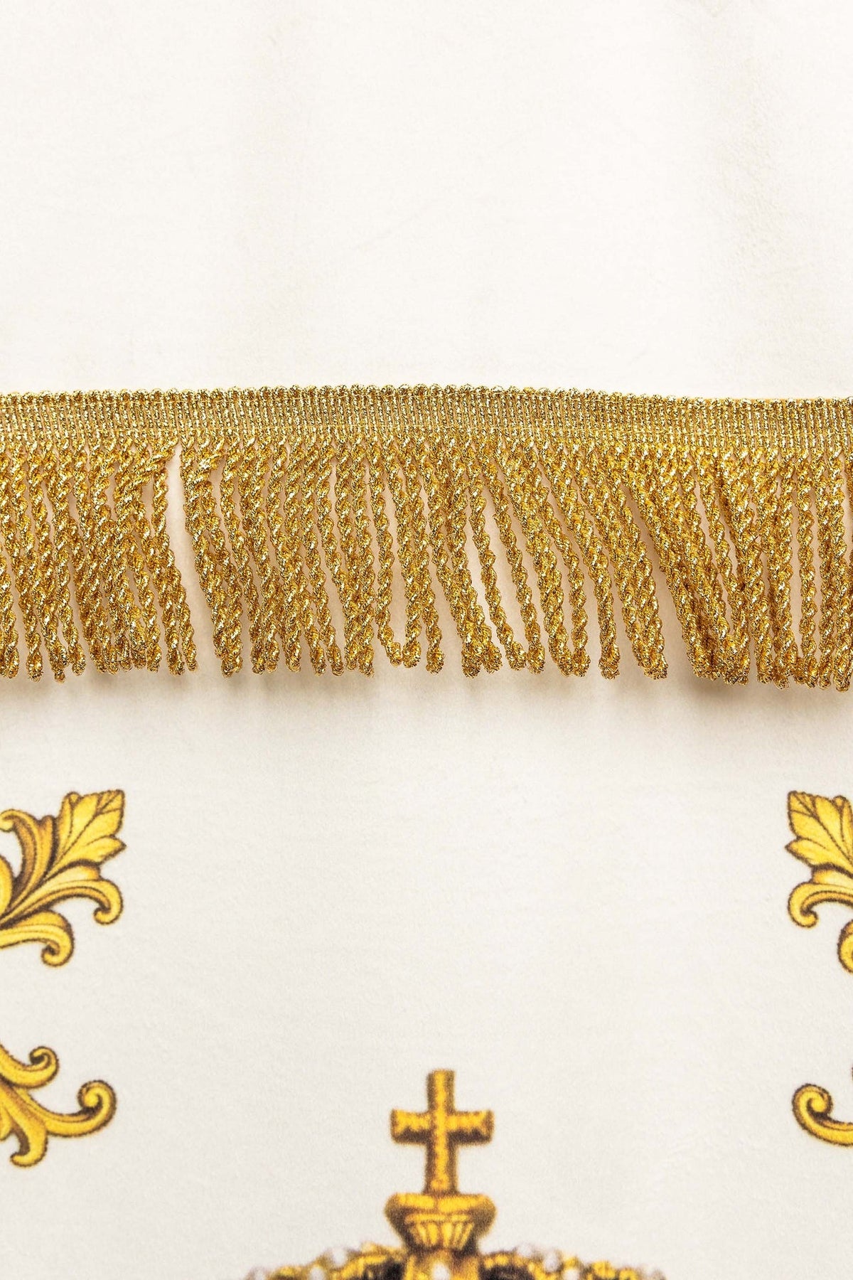 Close-up of the liturgical banner's gold fringe across the white fabric