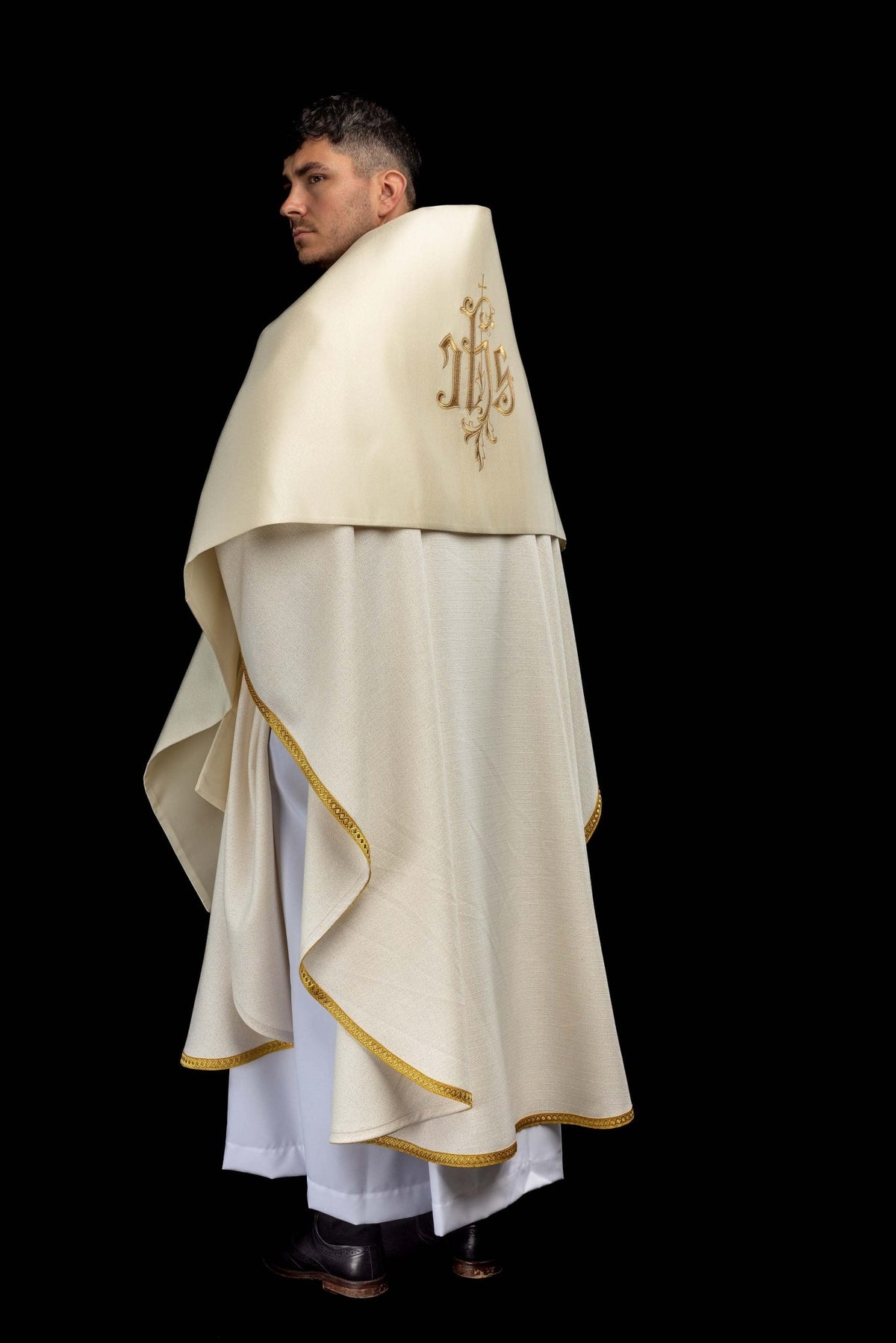 Side view of the ecru humeral veil with gold edging and embroidered IHS motif