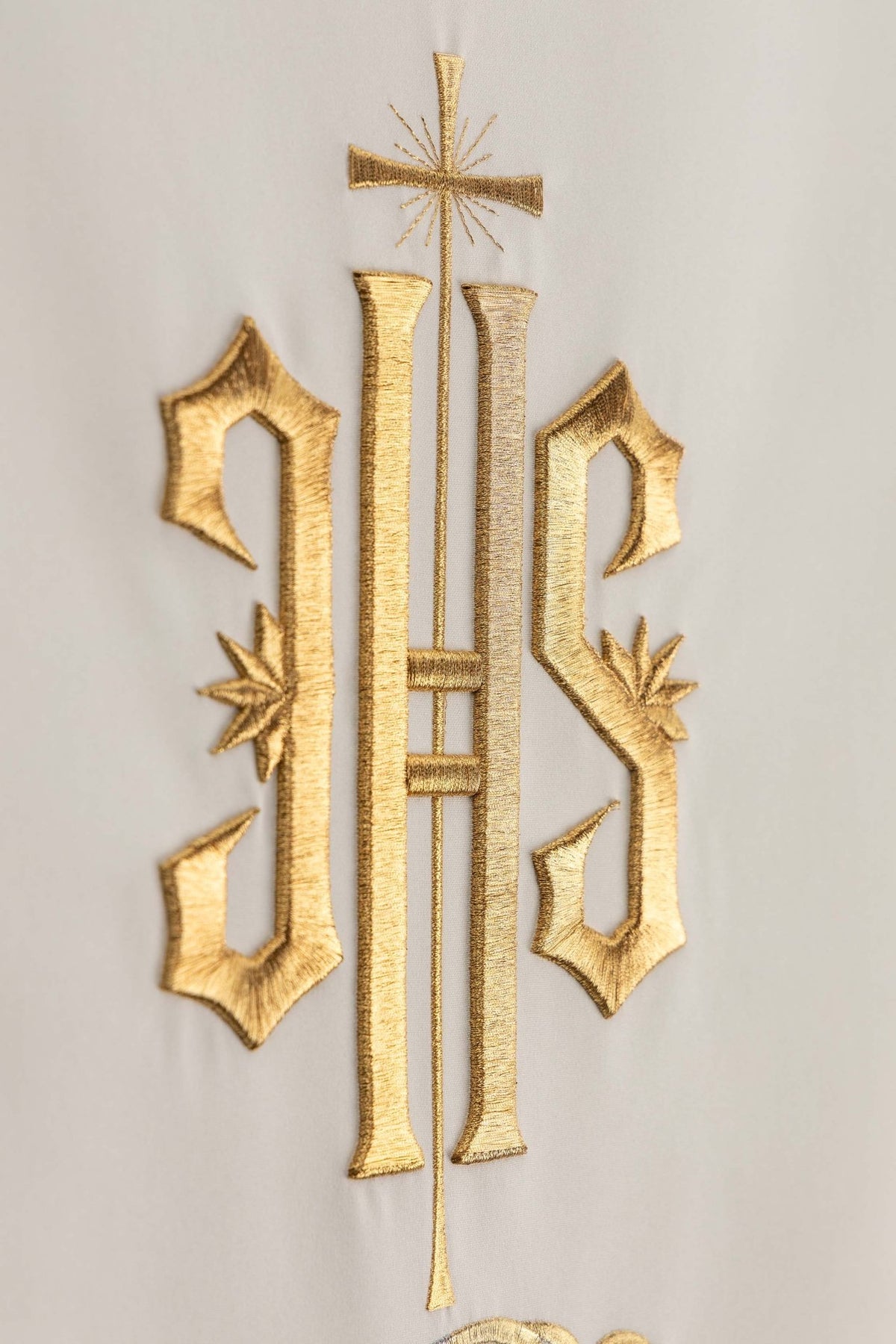 Close-up of the lectern cloth showing gold IHS embroidery and cross