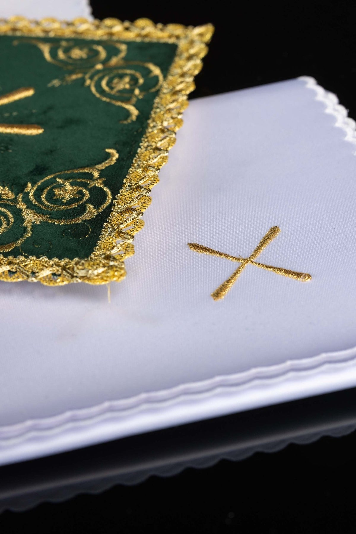Close-up of white chalice linens set with gold embroidered crosses and scalloped edges