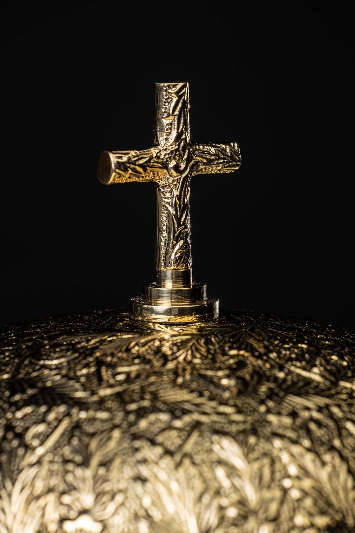 Close-up of the gong’s crucifix finial and engraved brass dome