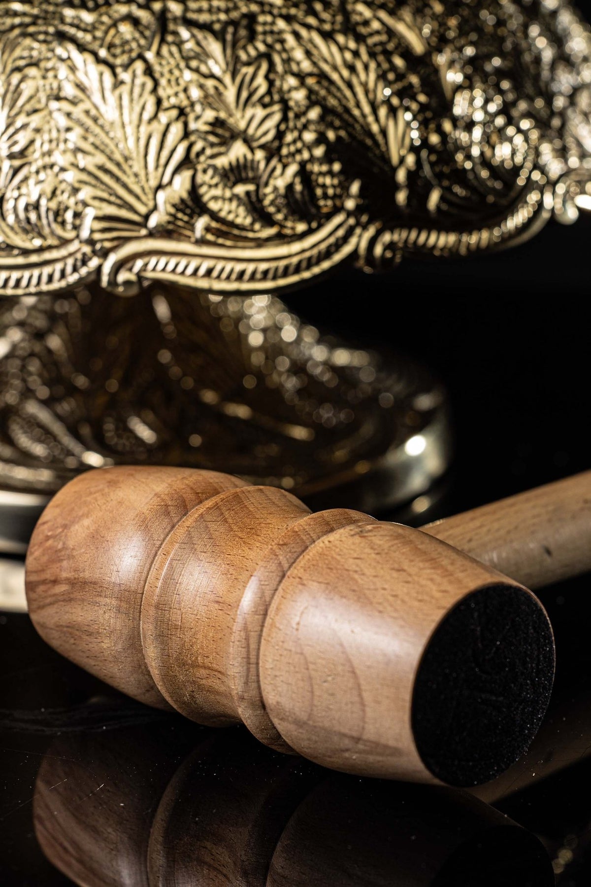 Close-up of the wooden mallet with dark striking head for the gong