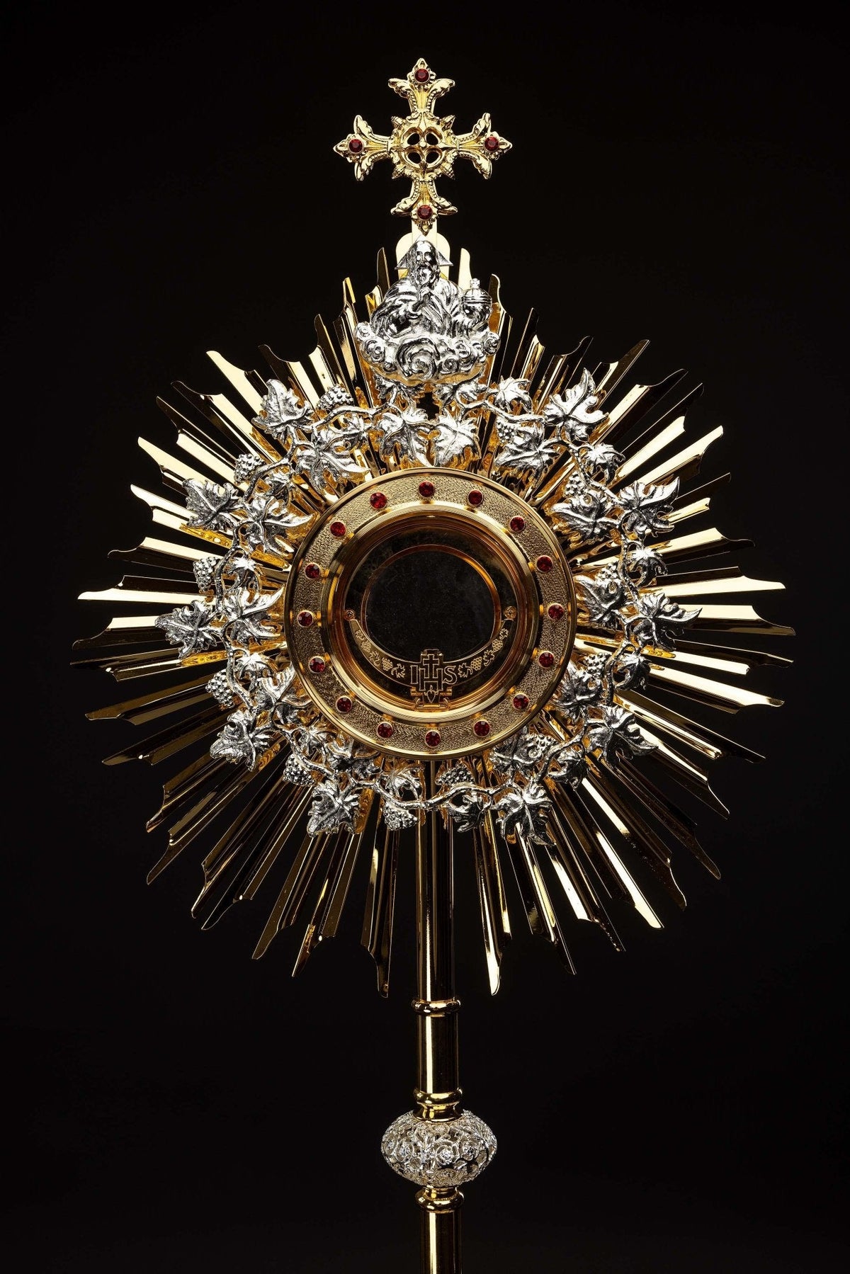 Front view of the gilded brass monstrance showing the cross, Christ figure, rubies and sunburst
