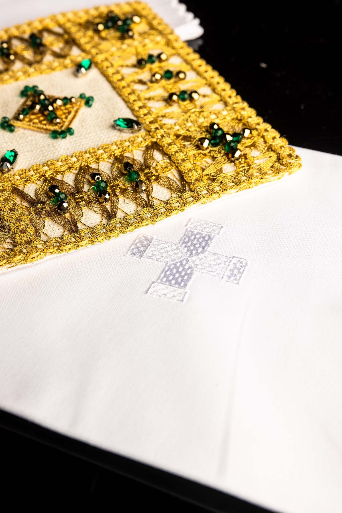 Angled detail of the altar linen set's chalice pall with jeweled gold floral embroidery