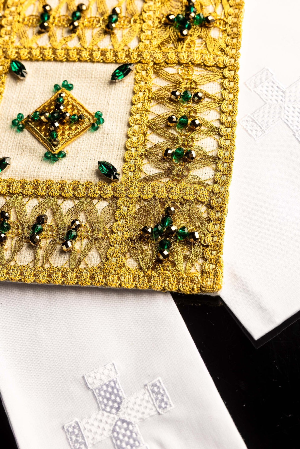 Side detail of the altar linen set's pall and white linen with embroidered cross