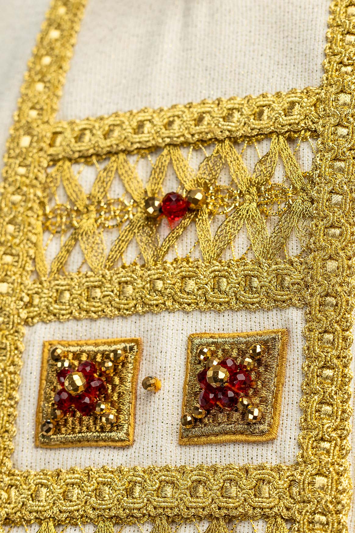 Close-up of the chasuble panel with openwork gold embroidery and red stone
