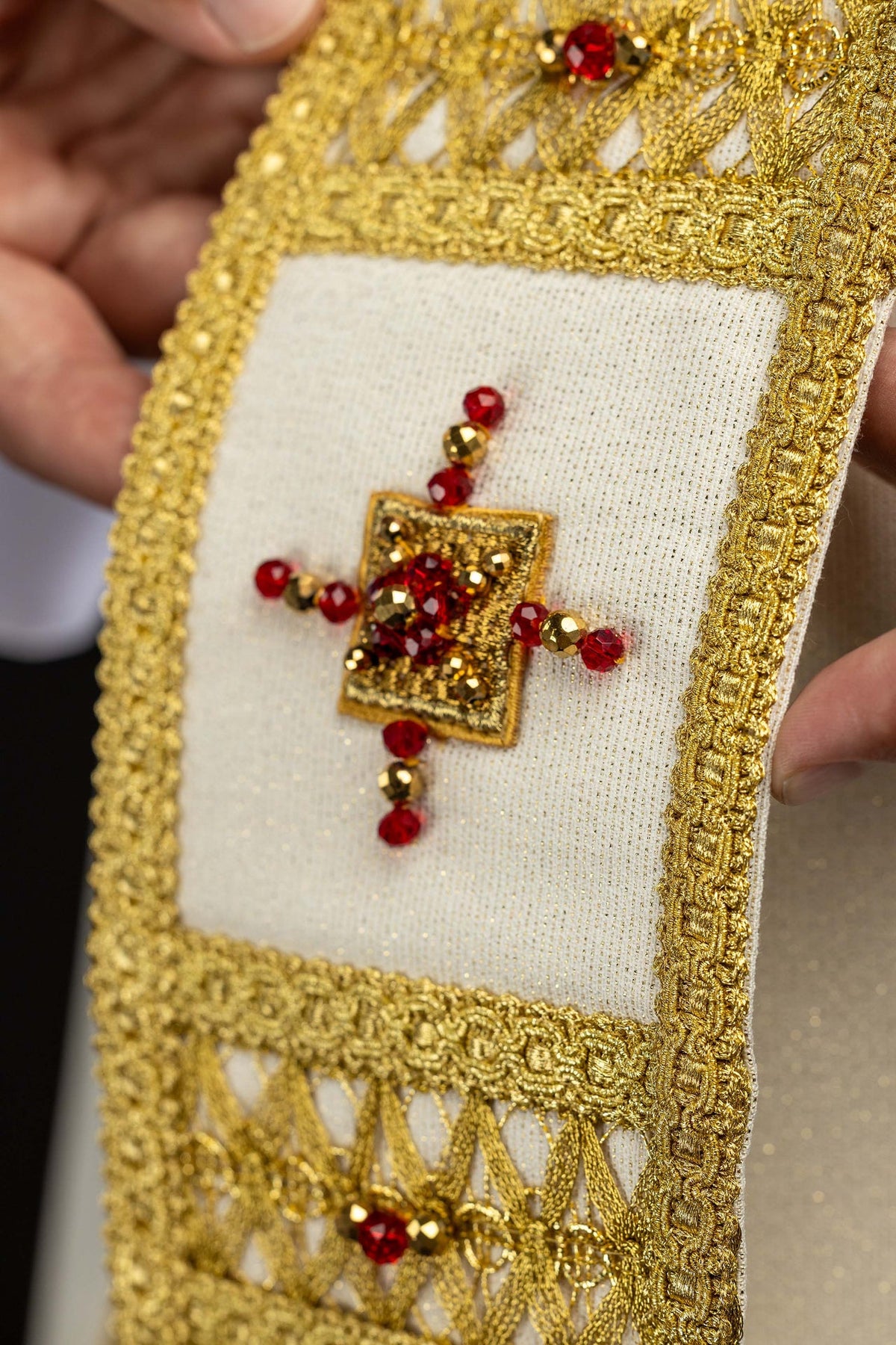 Close-up of the chasuble panel with a jeweled cross and gold openwork trim