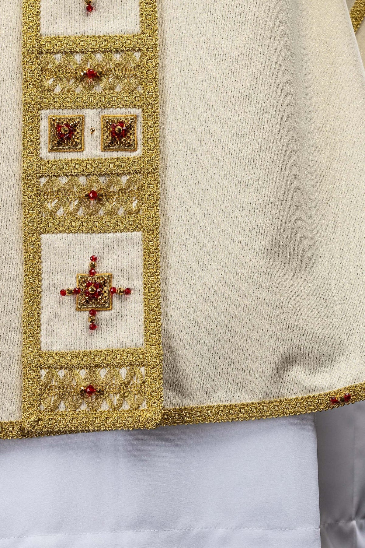 Detail of the chasuble sleeve edge with gold trim and red stones