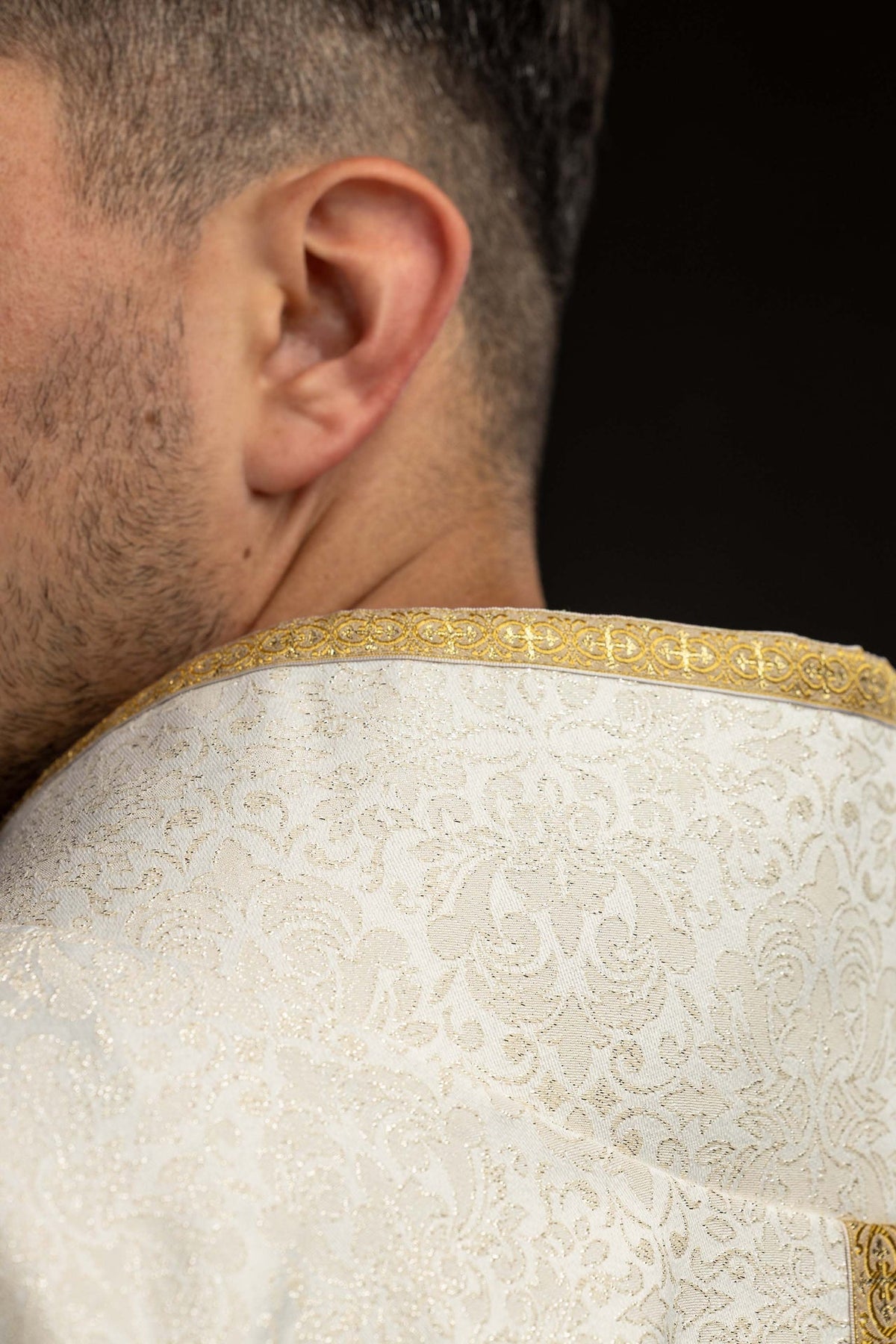 Back view detail of the chasuble with gold neckline trim and woven pattern