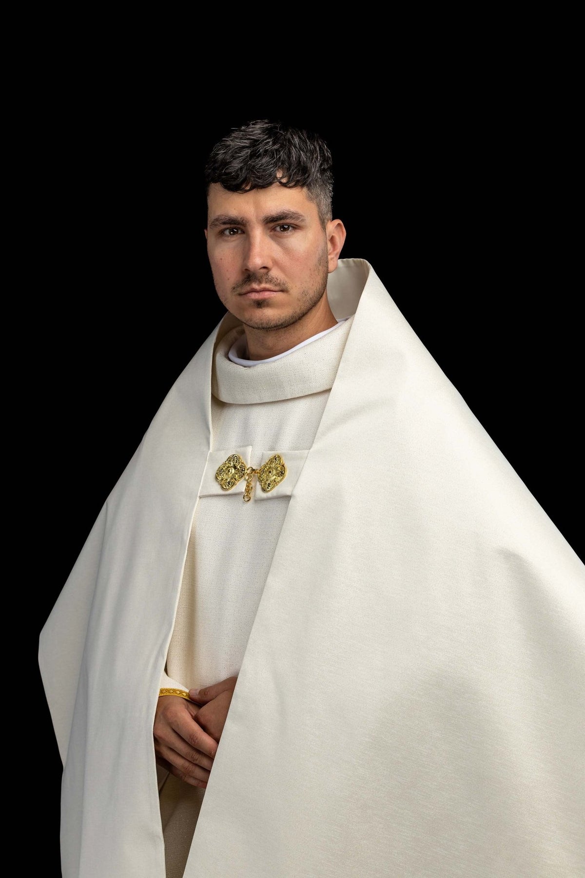 Worn front view of the humeral veil with gold clasps and plain ecru panels