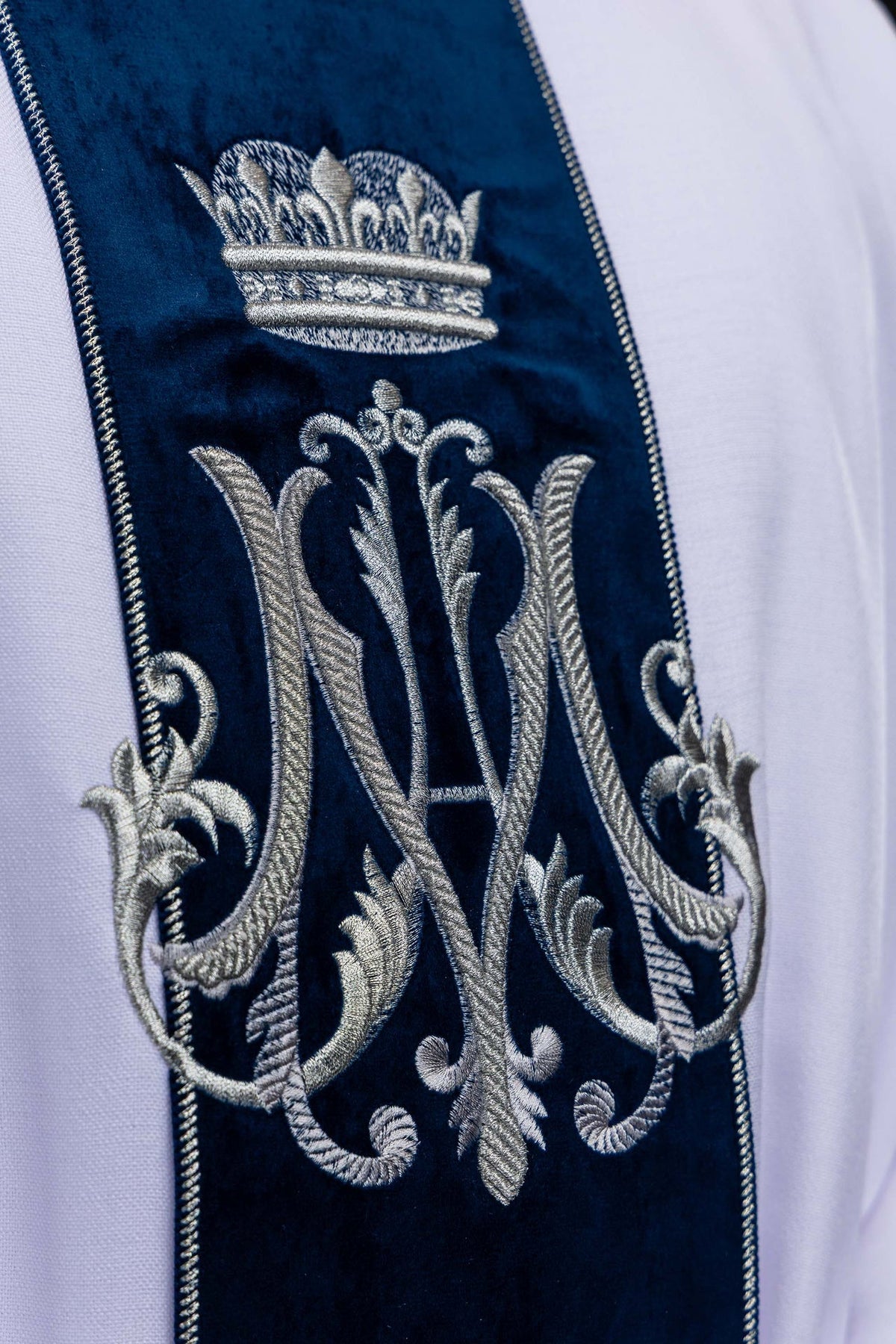 Close-up of the Marian chasuble showing silver embroidered monogram and crown on blue velvet