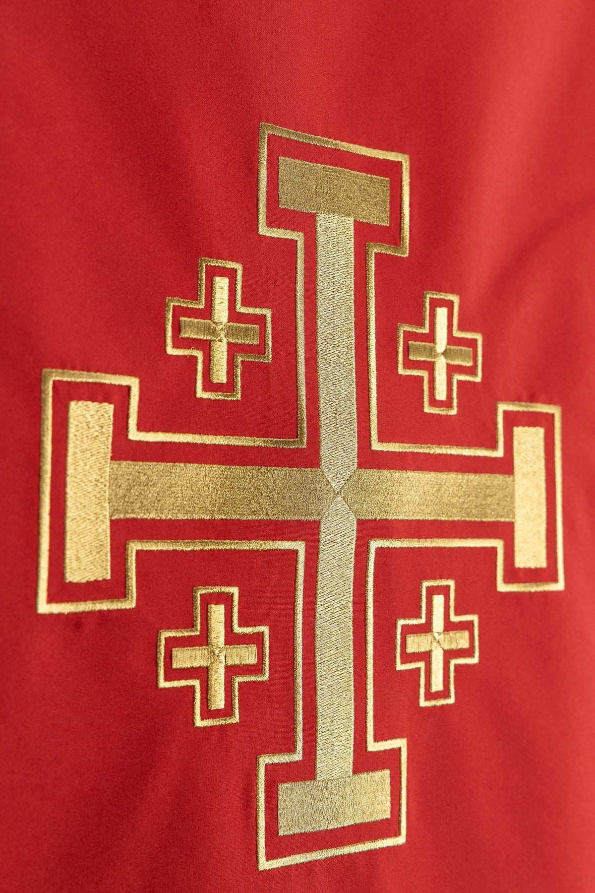 Close-up of the church lectern cover with gold embroidery and a Jerusalem cross on red fabric