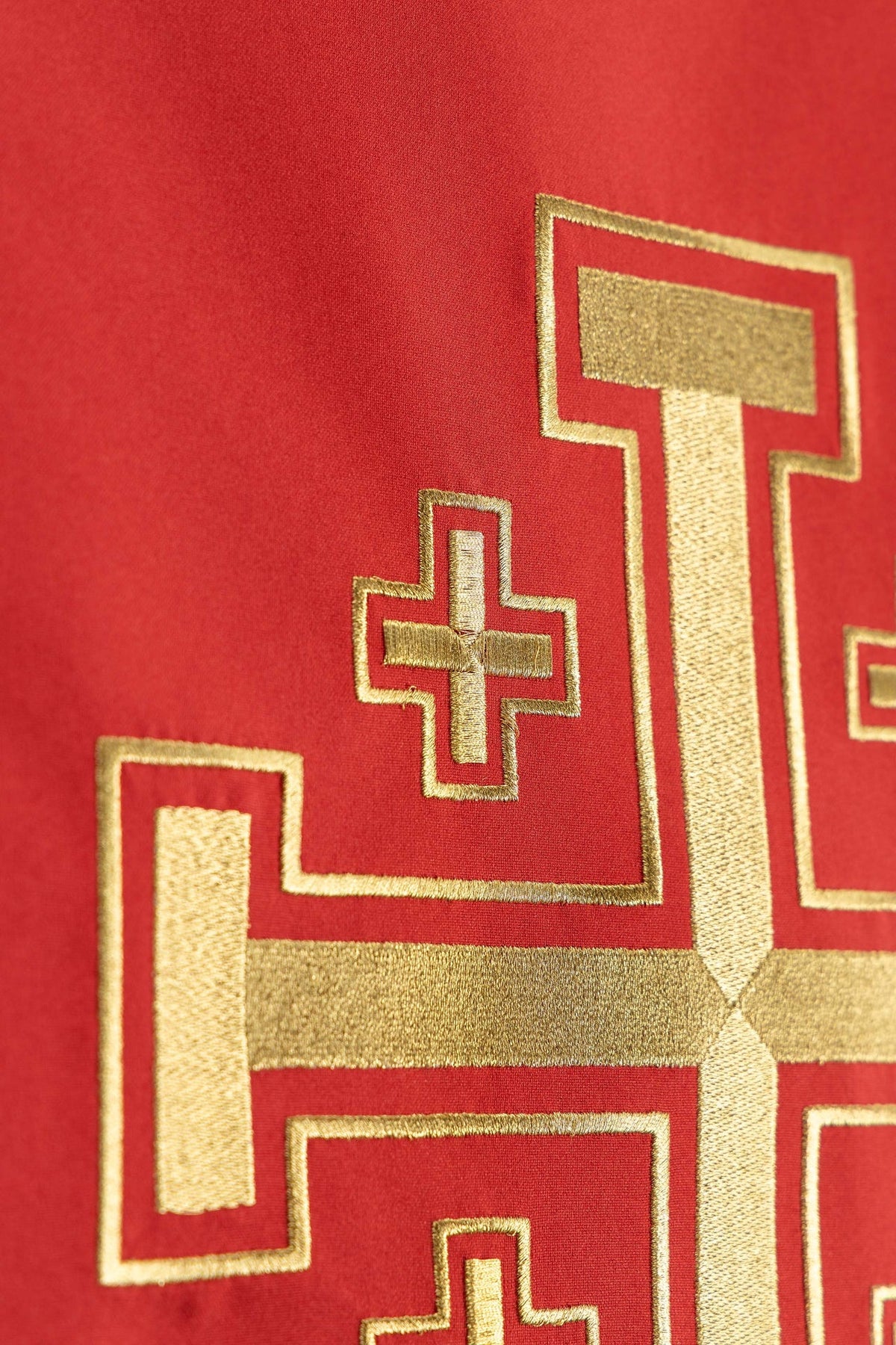 Detail view of the lectern cover showing gold Jerusalem cross embroidery on red fabric