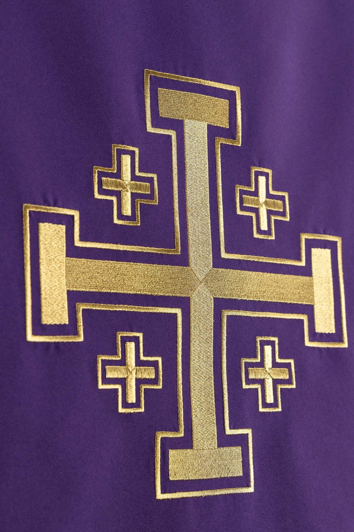 Close-up of the purple church lectern cover showing gold Jerusalem cross embroidery