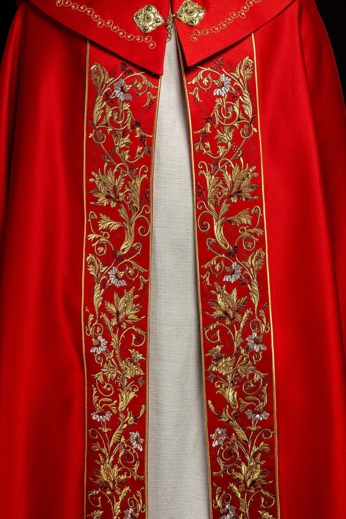 Front detail of red cope showing symmetrical gold and multicolor floral embroidery