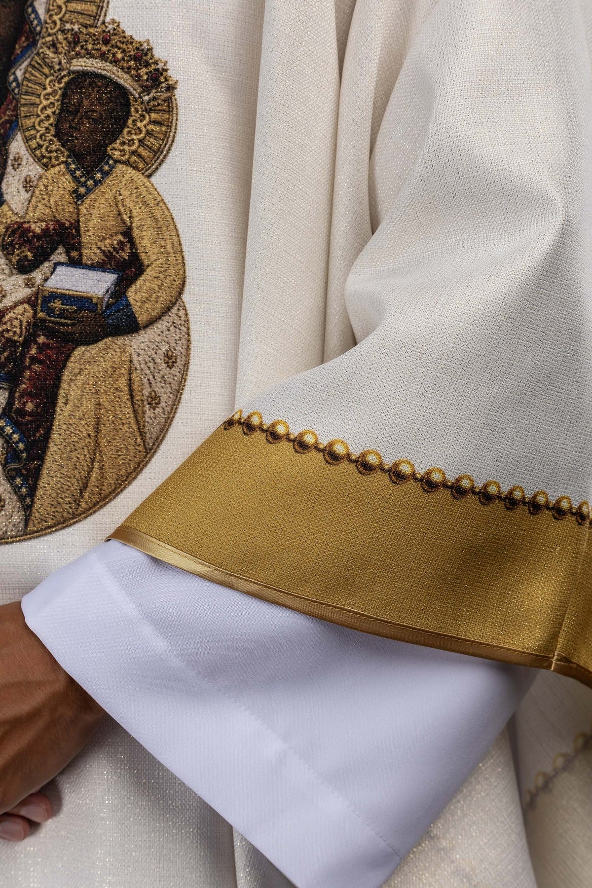 Close-up of the chasuble sleeve with gold trim and beaded edging