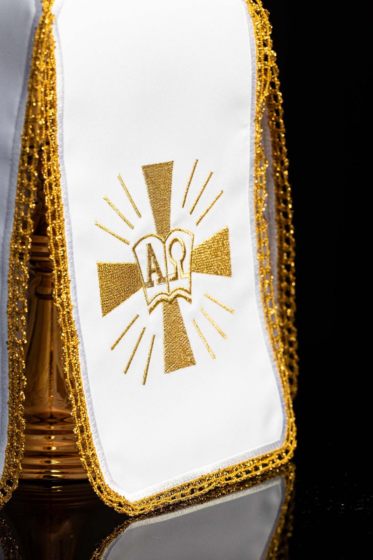 Close-up of ciborium veil showing gold embroidered Alpha and Omega with radiating lines