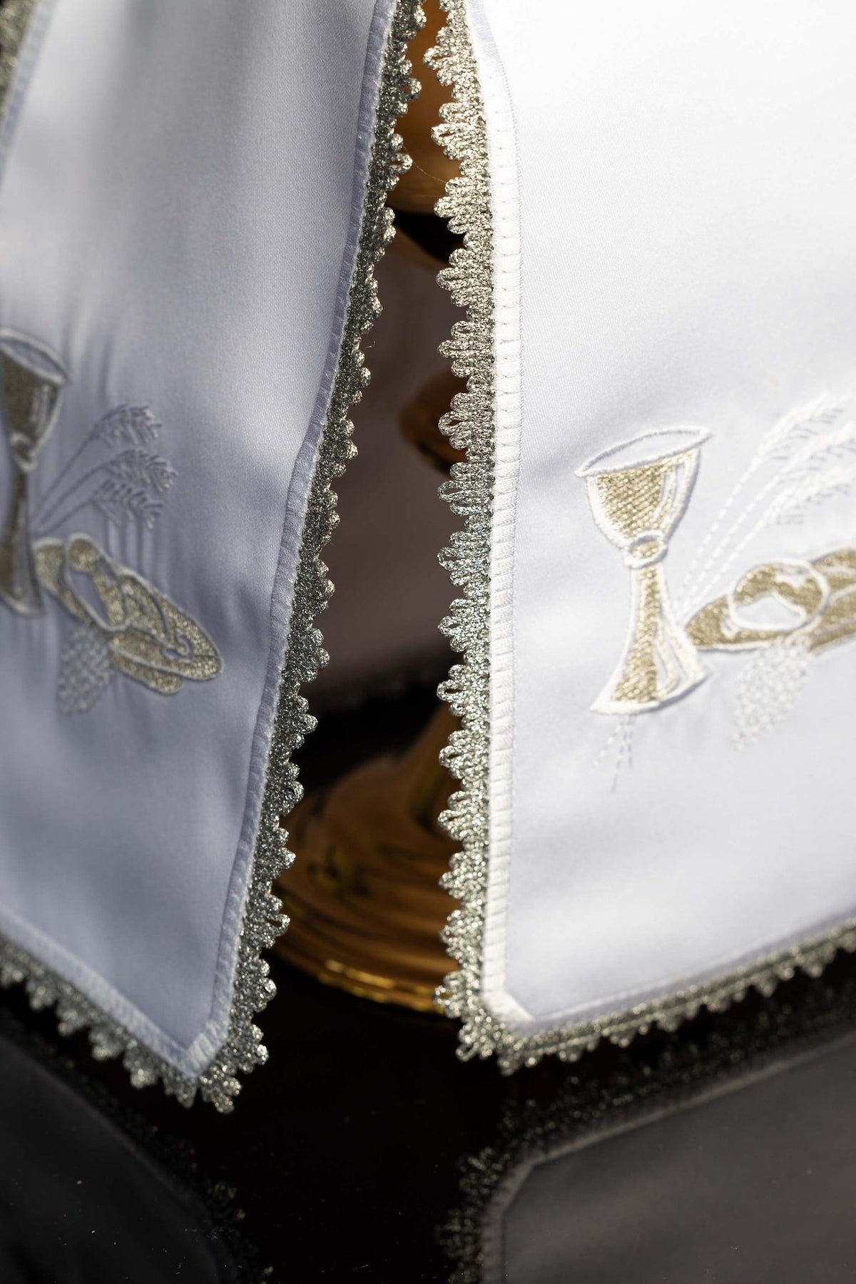 Side detail of the ciborium veil showing matching Eucharistic embroidery and silver trim