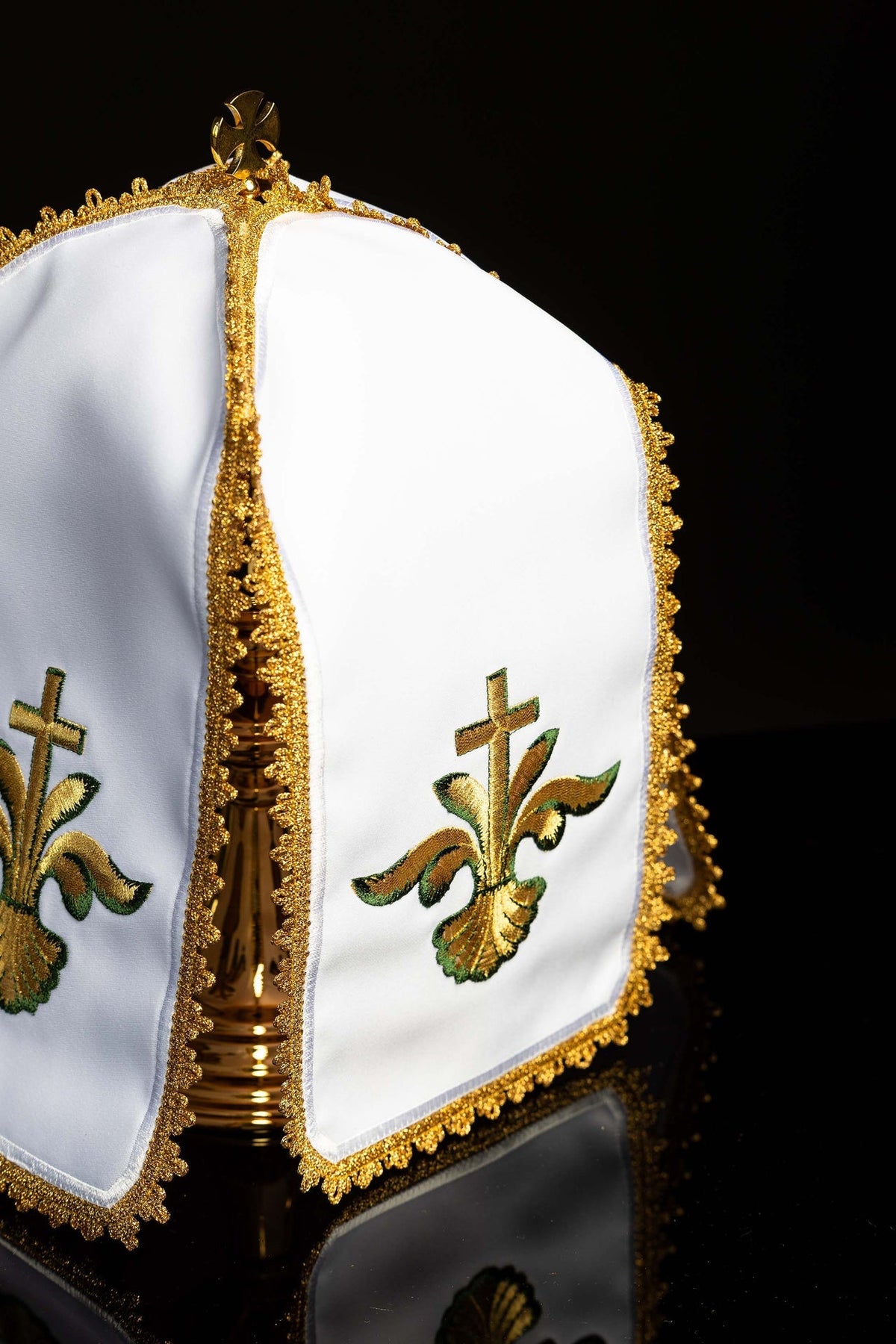 Angled view of the white ciborium veil showing gold edging and embroidered floral crosses