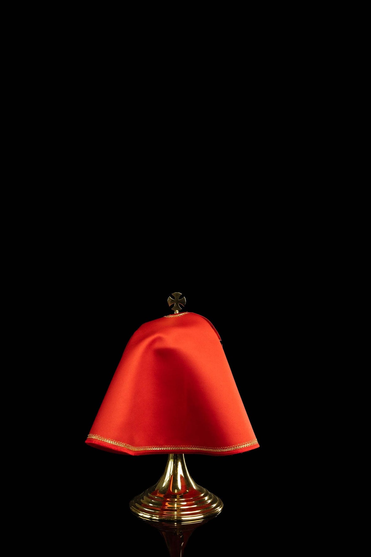 Back view of a red ciborium veil with gold trim and plain red fabric