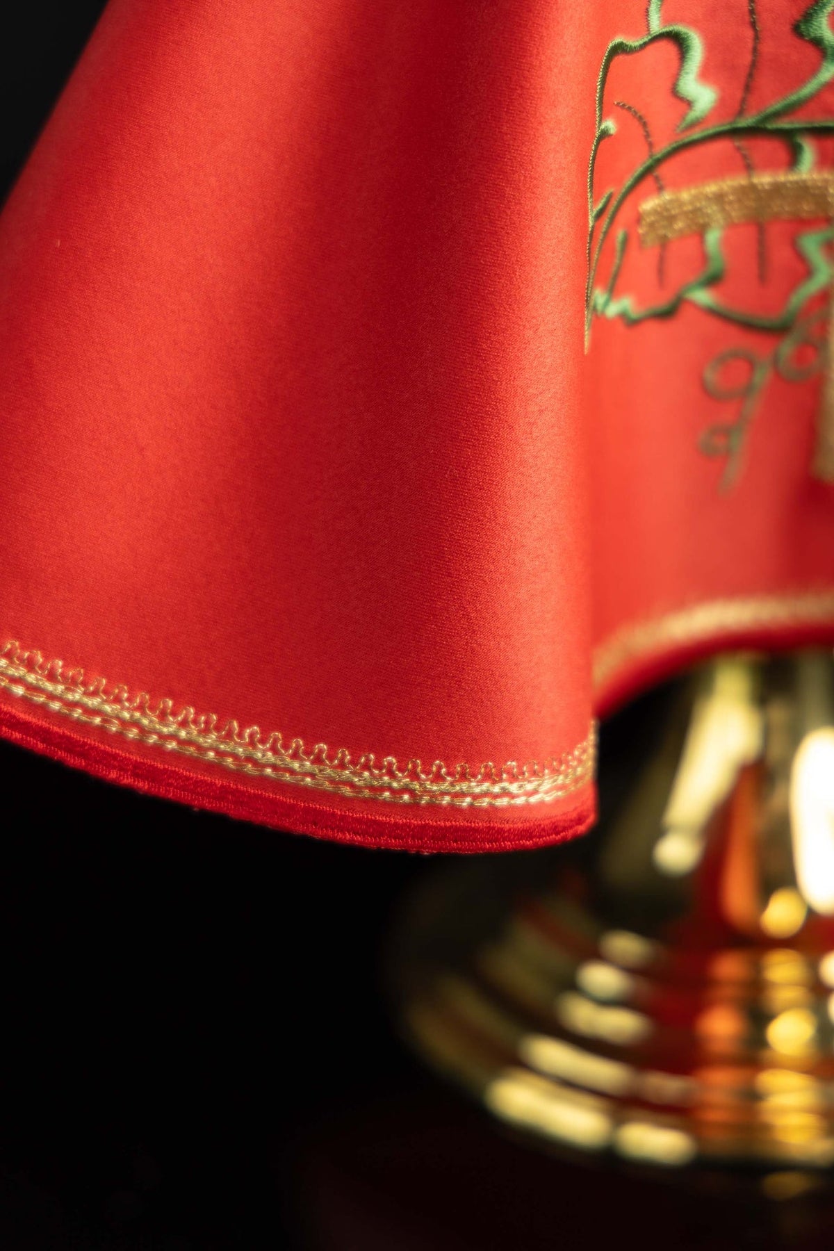 Close-up of a red ciborium veil showing gold embroidered edge trim