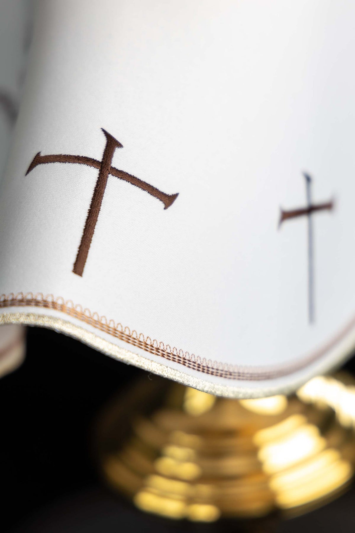 Close-up of ciborium veil edge with brown cross embroidery and gold trim