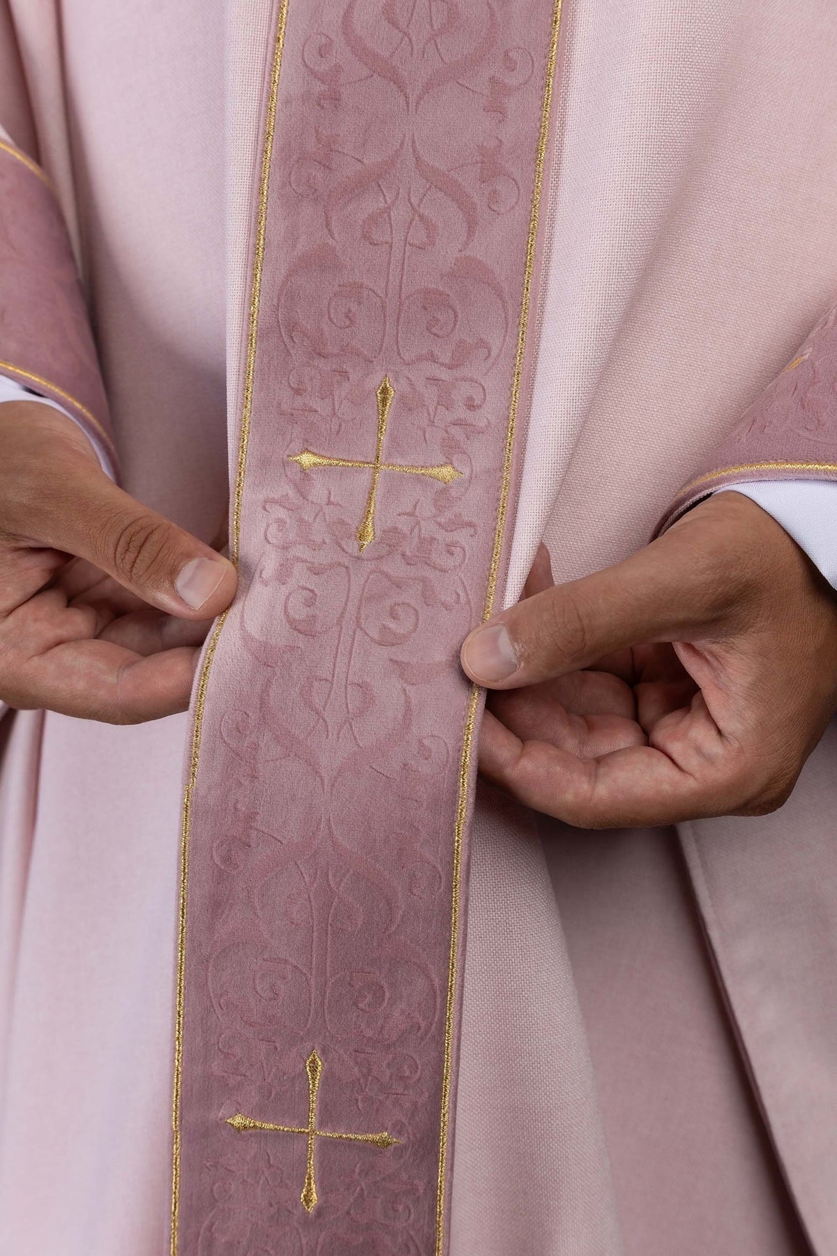 Close-up of the rose chasuble orphrey with embroidered gold crosses