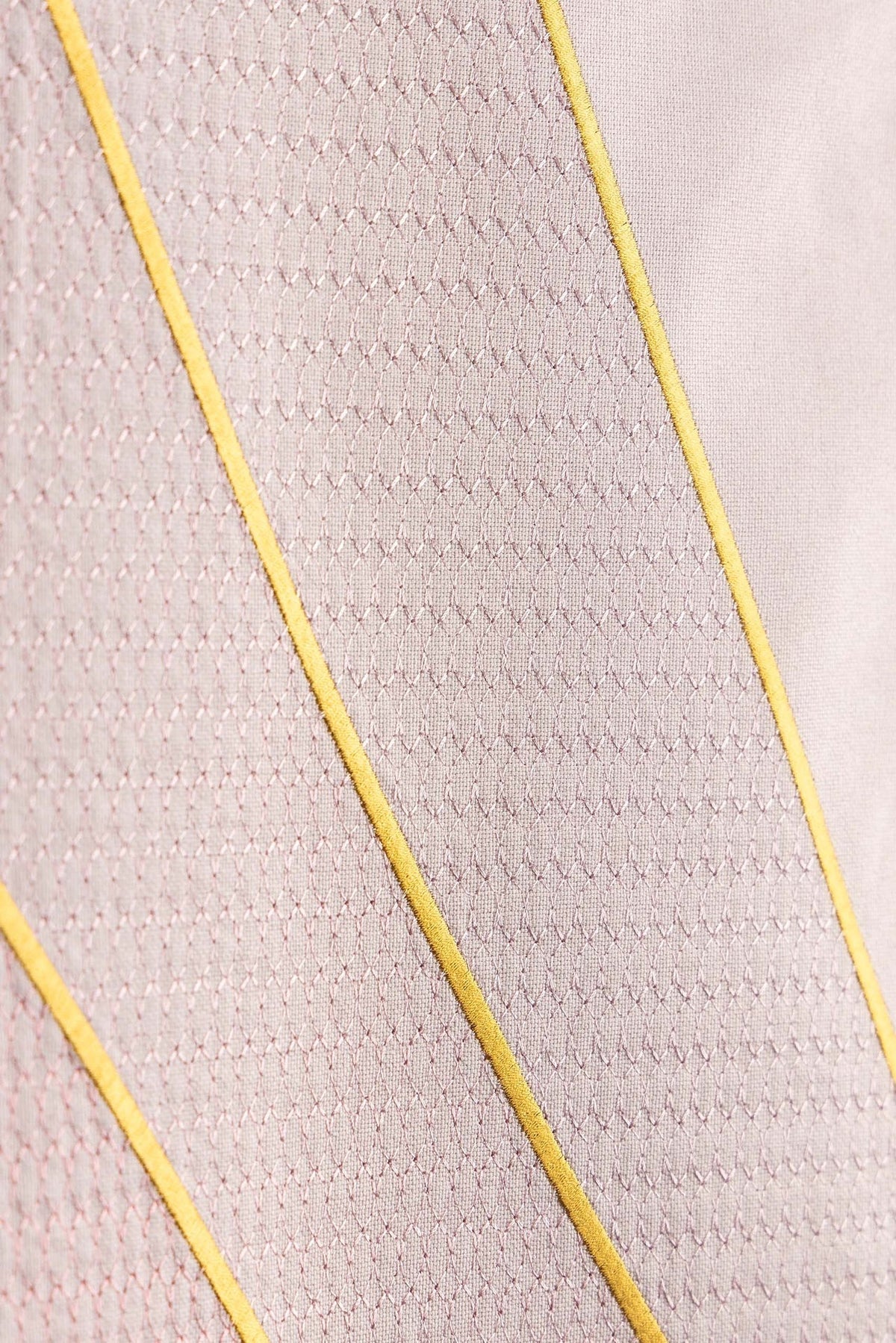 Close-up of rose lectern cloth showing gold wheat embroidery and geometric lines