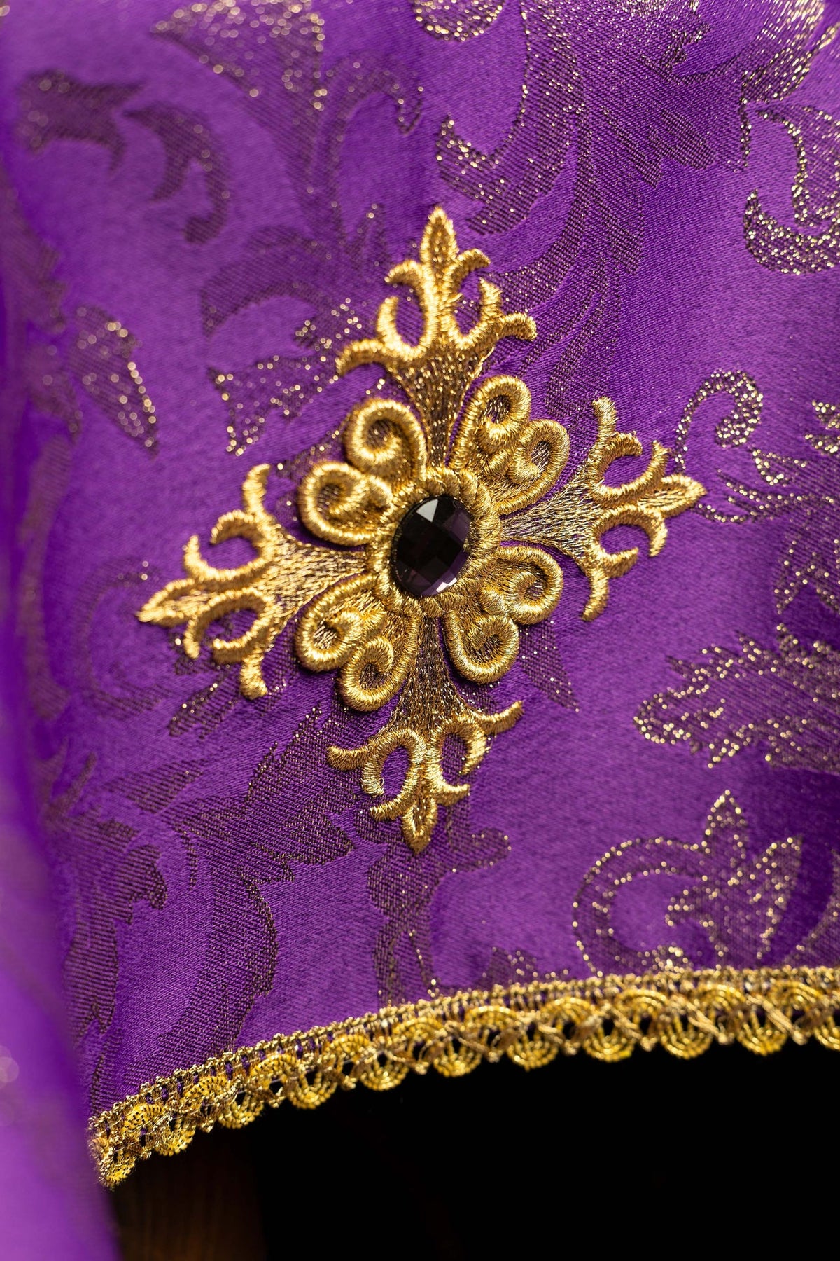Close-up of the chalice veil showing embroidered gold cross with a dark center jewel
