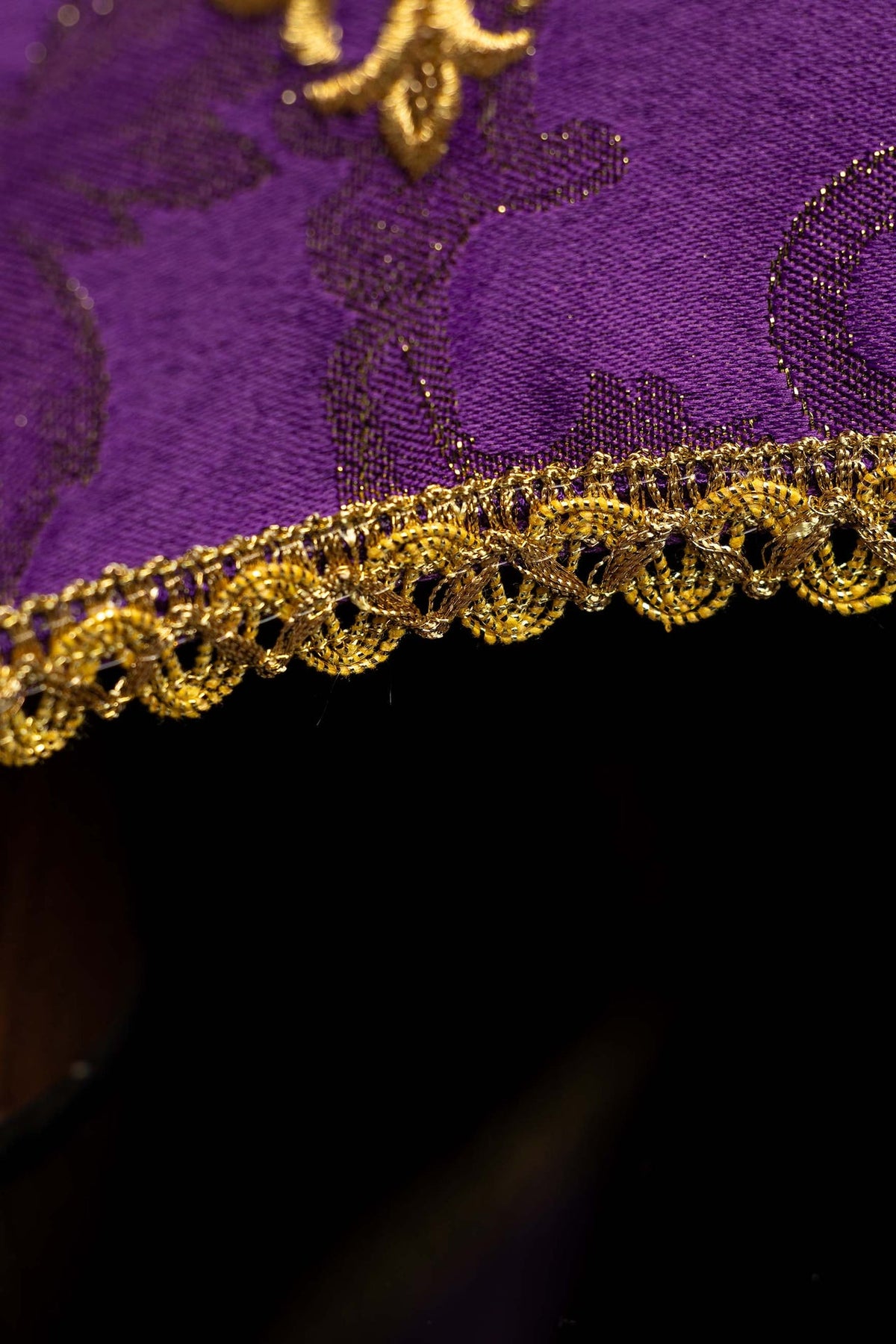 Close-up of the chalice veil showing purple patterned fabric and ornate gold edge trim