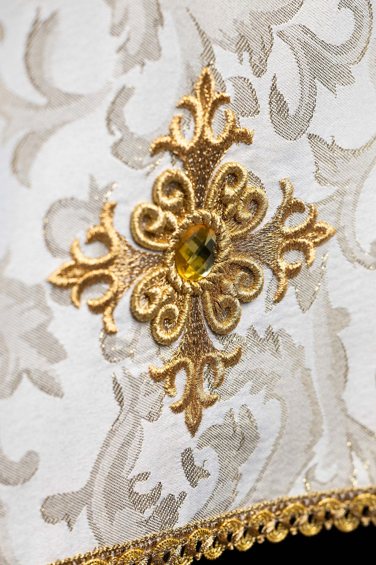 Close-up of the chalice veil showing embroidered gold cross with a central amber stone