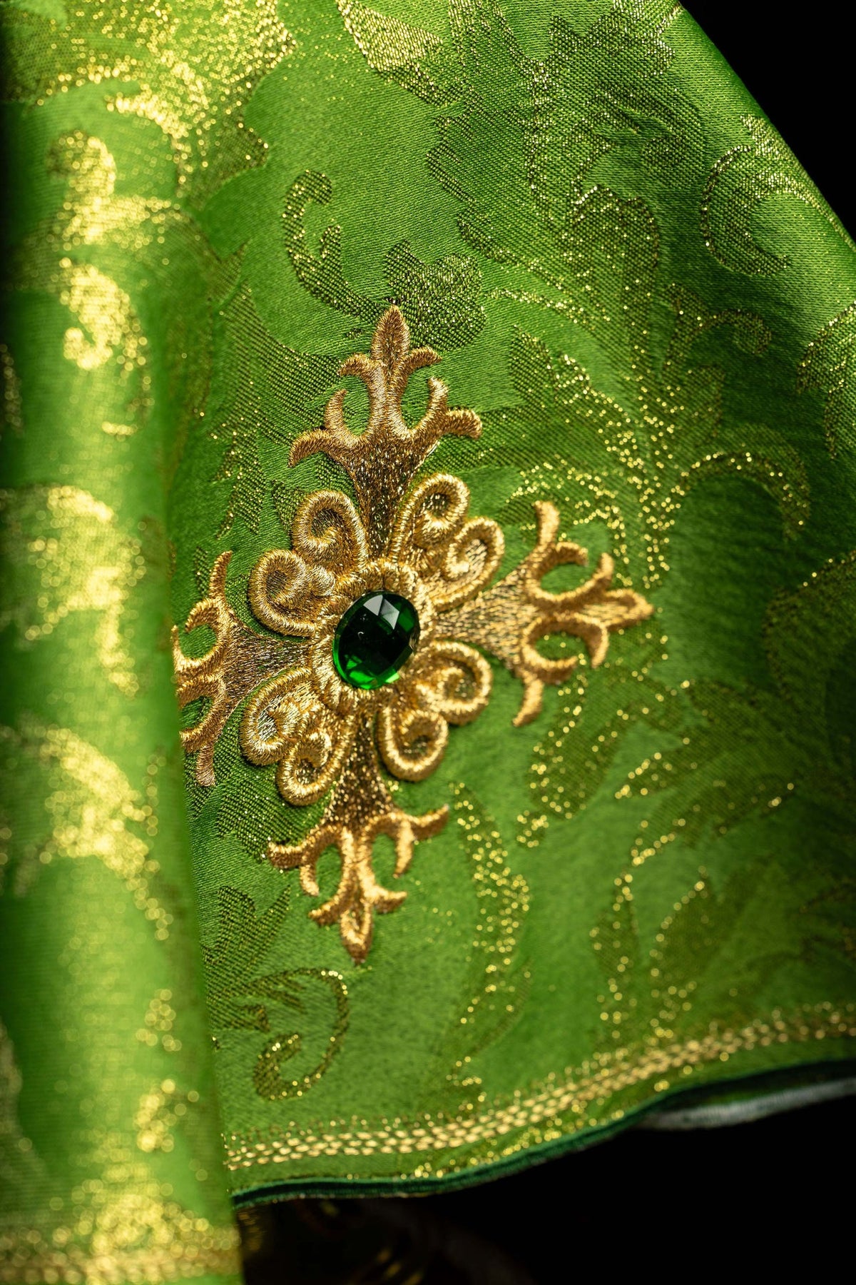 Close-up of the embroidered cross and green stone on the green ciborium veil