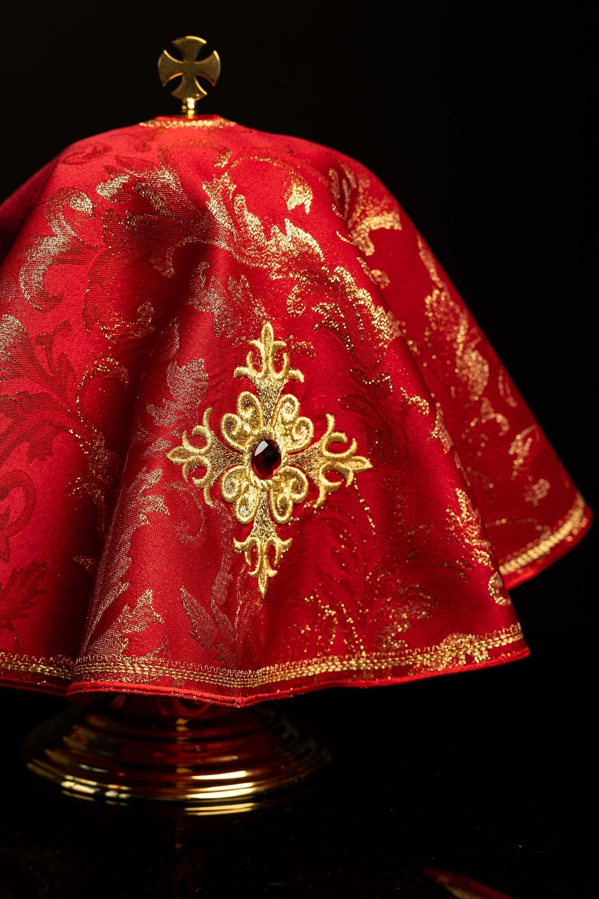 Angled view of the red ciborium veil with embroidered cross and red stone